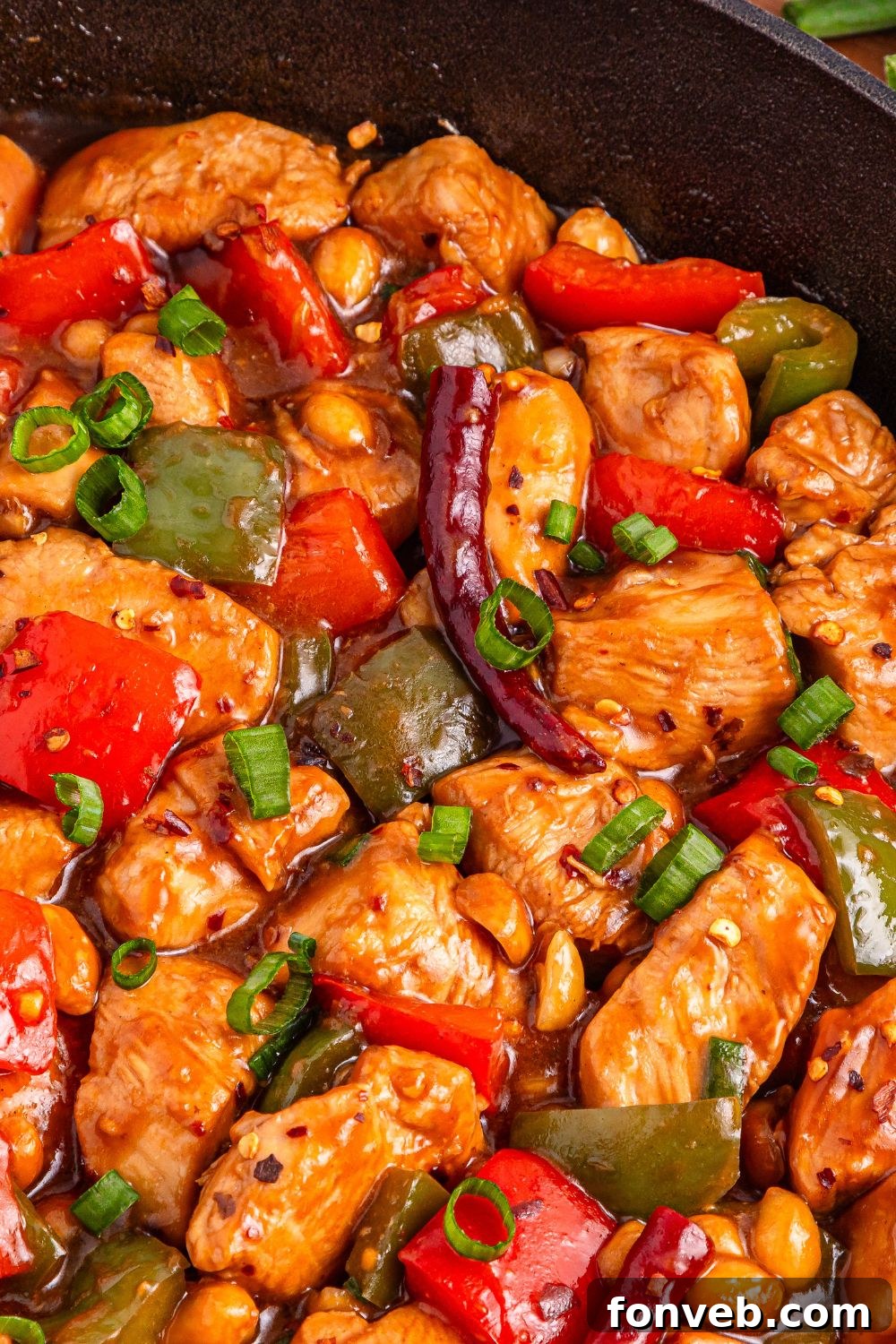 Better Than Takeout Kung Pao Chicken cooking in a pan on the stovetop, emitting delicious aromas.