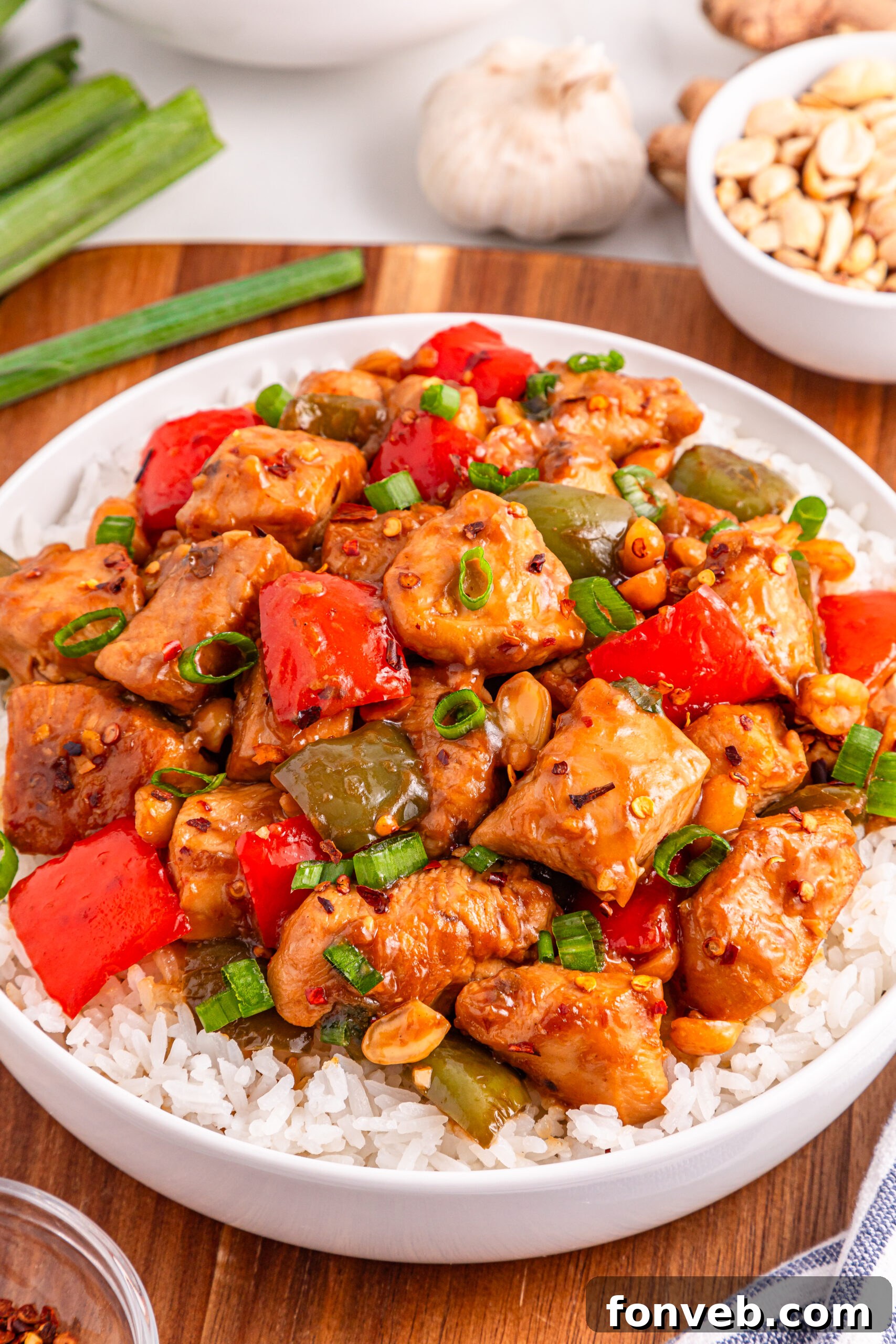 Better Than Takeout Kung Pao Chicken presented in a large white bowl, garnished and ready for serving.
