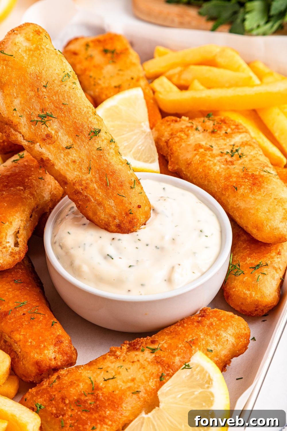 Effortless Homemade Tartar Sauce Beats Store Bought 15 A perfectly fried fish fillet being dipped into a bowl of Easy Homemade Tartar Sauce, highlighting its irresistible appeal.