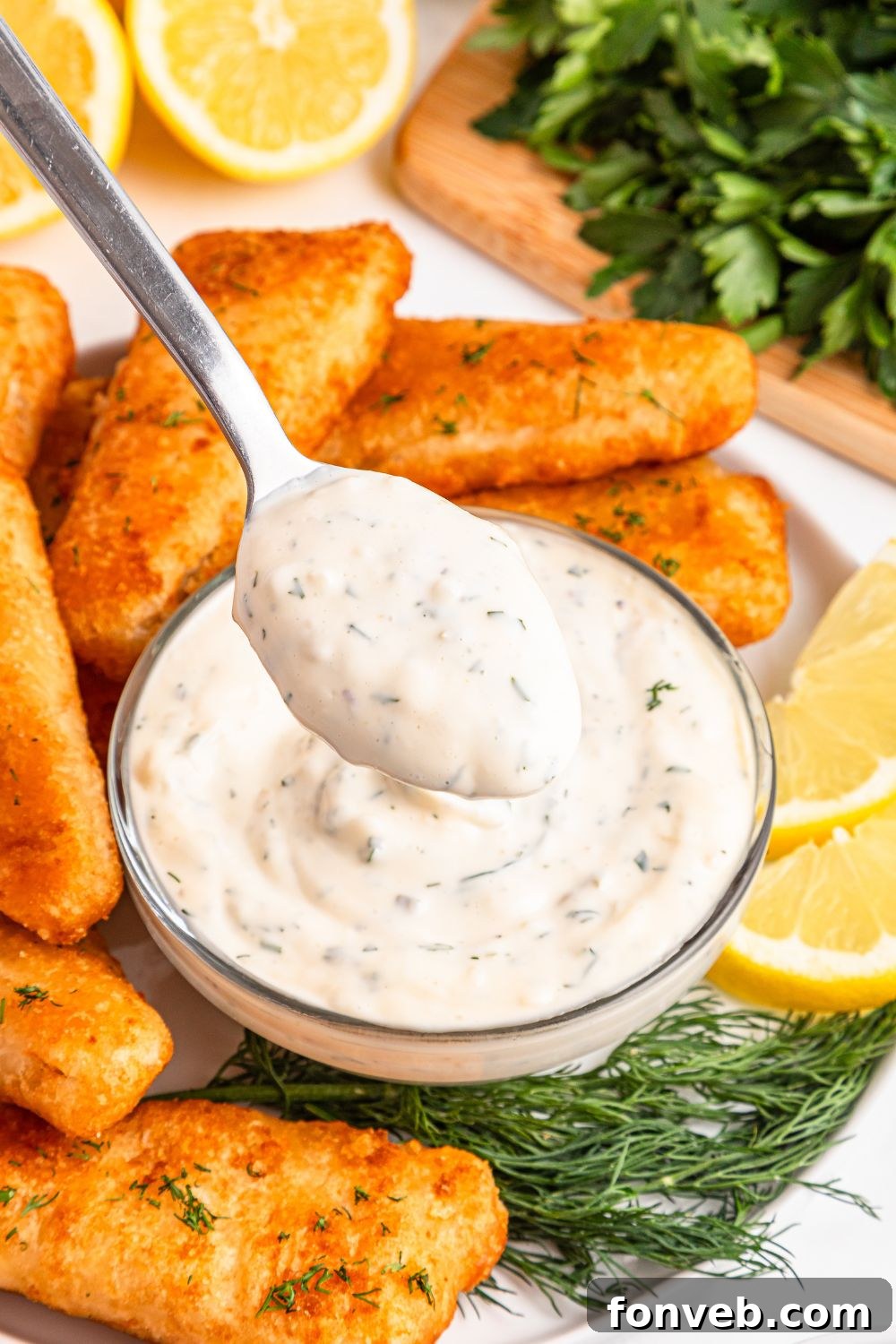 Effortless Homemade Tartar Sauce Beats Store Bought 17 Easy Homemade Tartar Sauce in a clear glass bowl with a spoon scooping some up, showing its rich, thick texture.