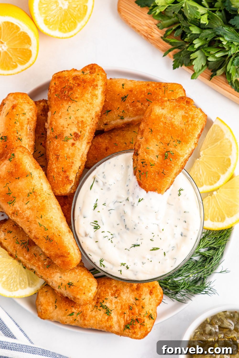 Effortless Homemade Tartar Sauce Beats Store Bought 18 A tray filled with fried fish, with a small bowl of Easy Homemade Tartar Sauce in the center, inviting diners to dip.