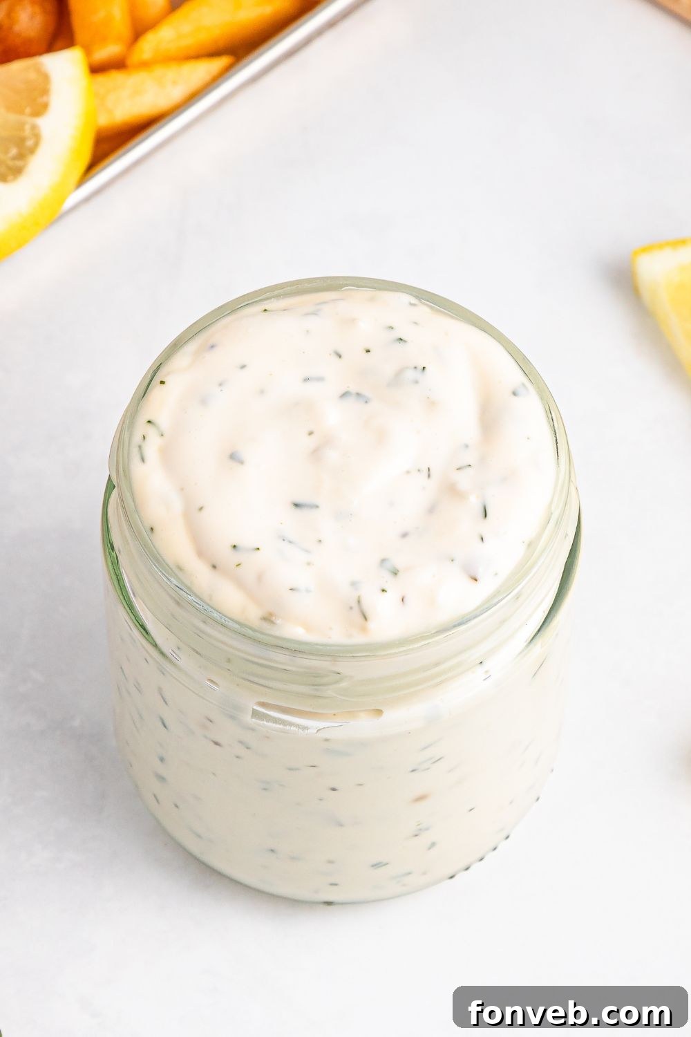 Effortless Homemade Tartar Sauce Beats Store Bought 19 Easy Homemade Tartar Sauce in a elegant glass jar, accompanied by fresh lemon slices and a sprig of dill on the side.