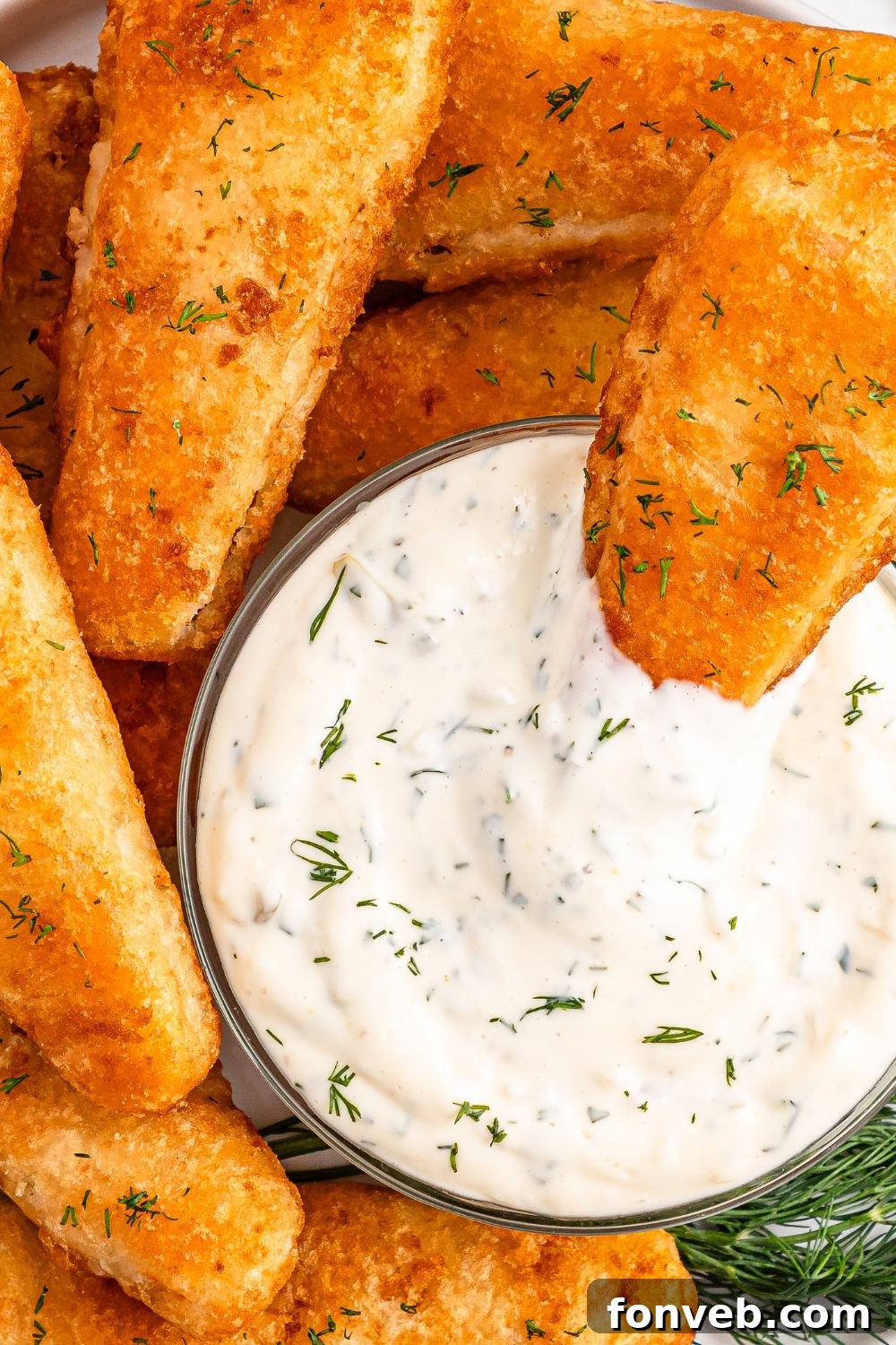 Effortless Homemade Tartar Sauce Beats Store Bought 20 A bowl of Easy Homemade Tartar Sauce with a piece of crispy fish being dipped into it, highlighting the perfect pairing.