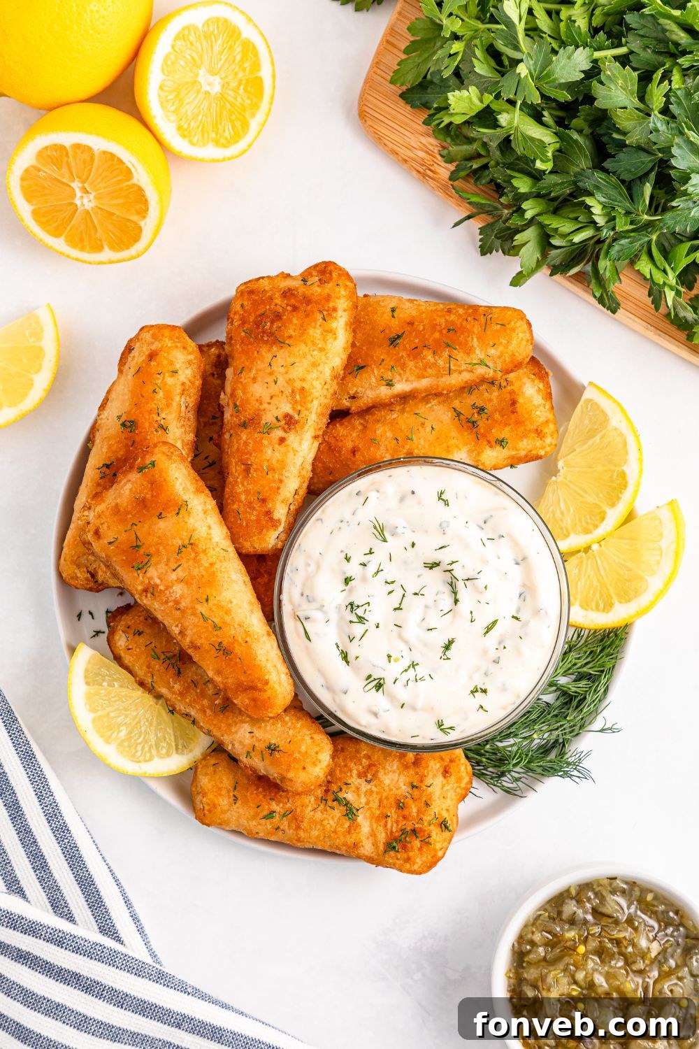 Effortless Homemade Tartar Sauce Beats Store Bought 22 Easy Homemade Tartar Sauce in a bowl, surrounded by perfectly fried fish fillets, lemon wedges, and fresh dill on a platter, showcasing a vibrant meal.