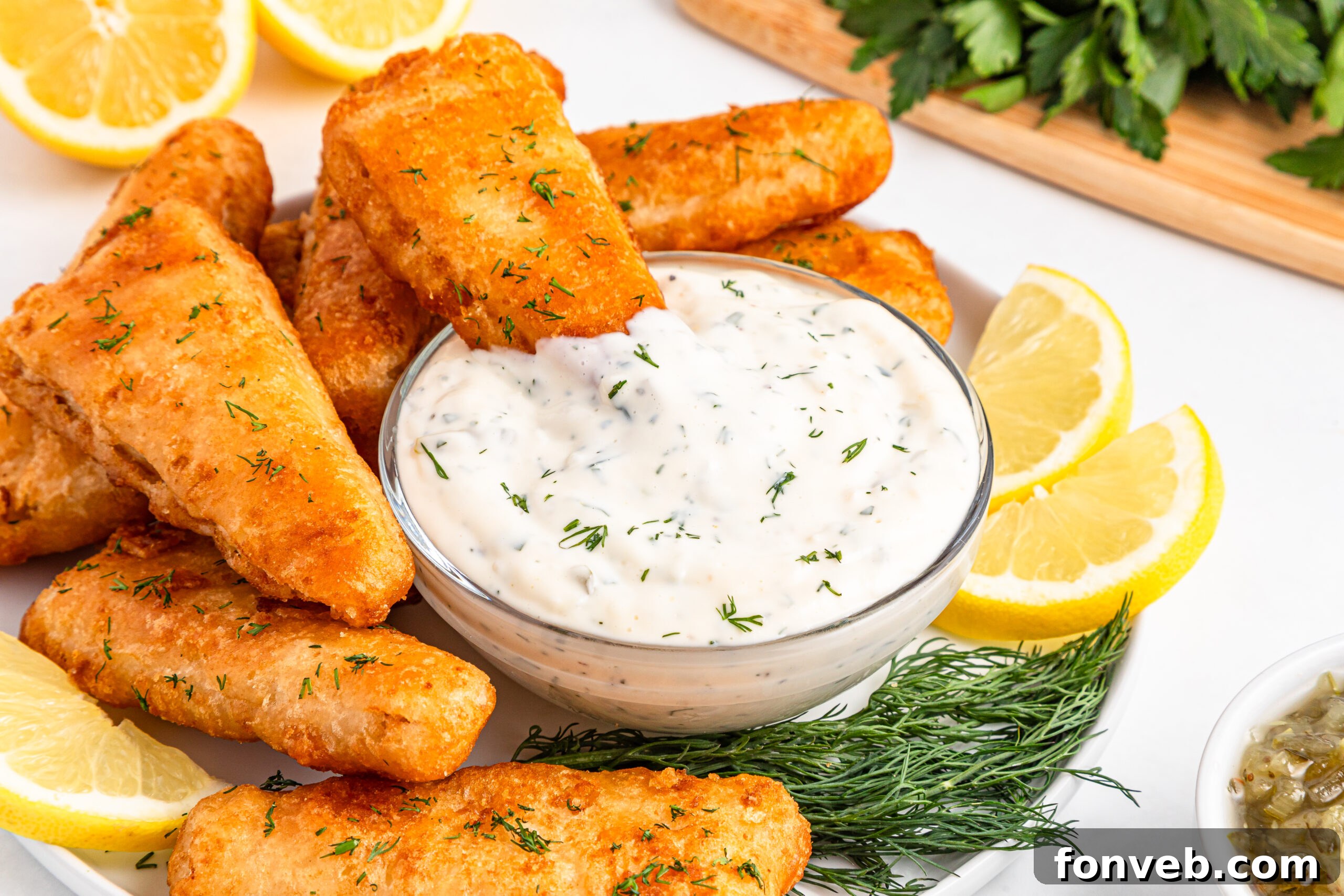 Effortless Homemade Tartar Sauce Beats Store Bought 26 A piece of fish being dipped into a bowl of creamy homemade tartar sauce, illustrating the perfect way to enjoy it.