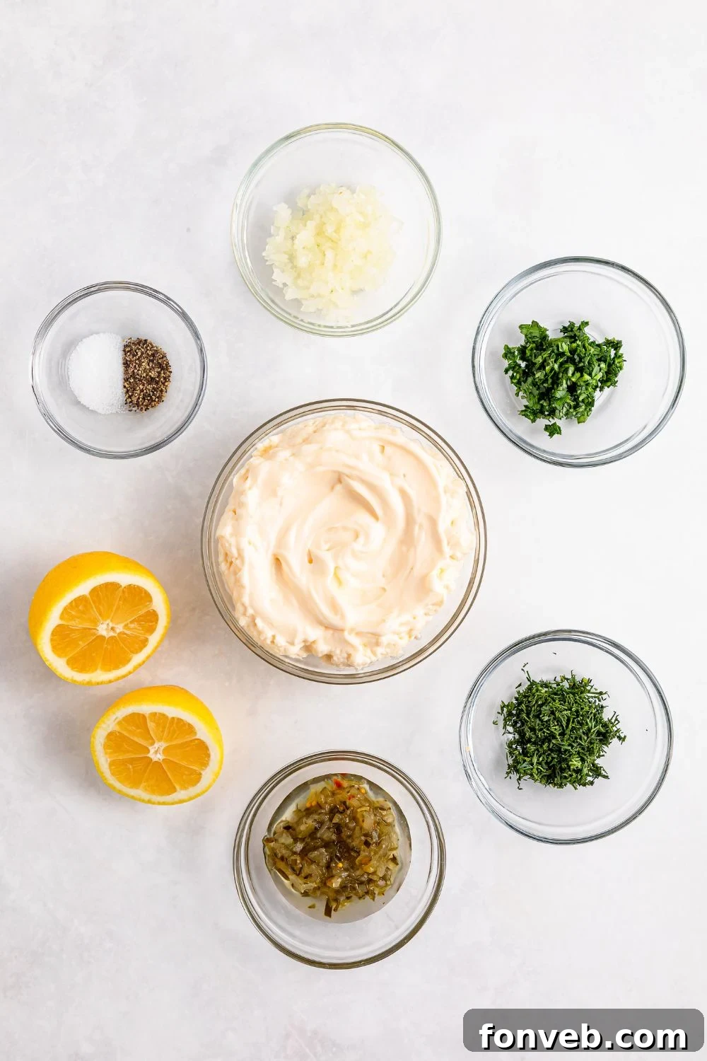 Effortless Homemade Tartar Sauce Beats Store Bought 10 Individual single-serve containers holding the fresh ingredients for tartar sauce, including mayonnaise, relish, and herbs, arranged neatly.