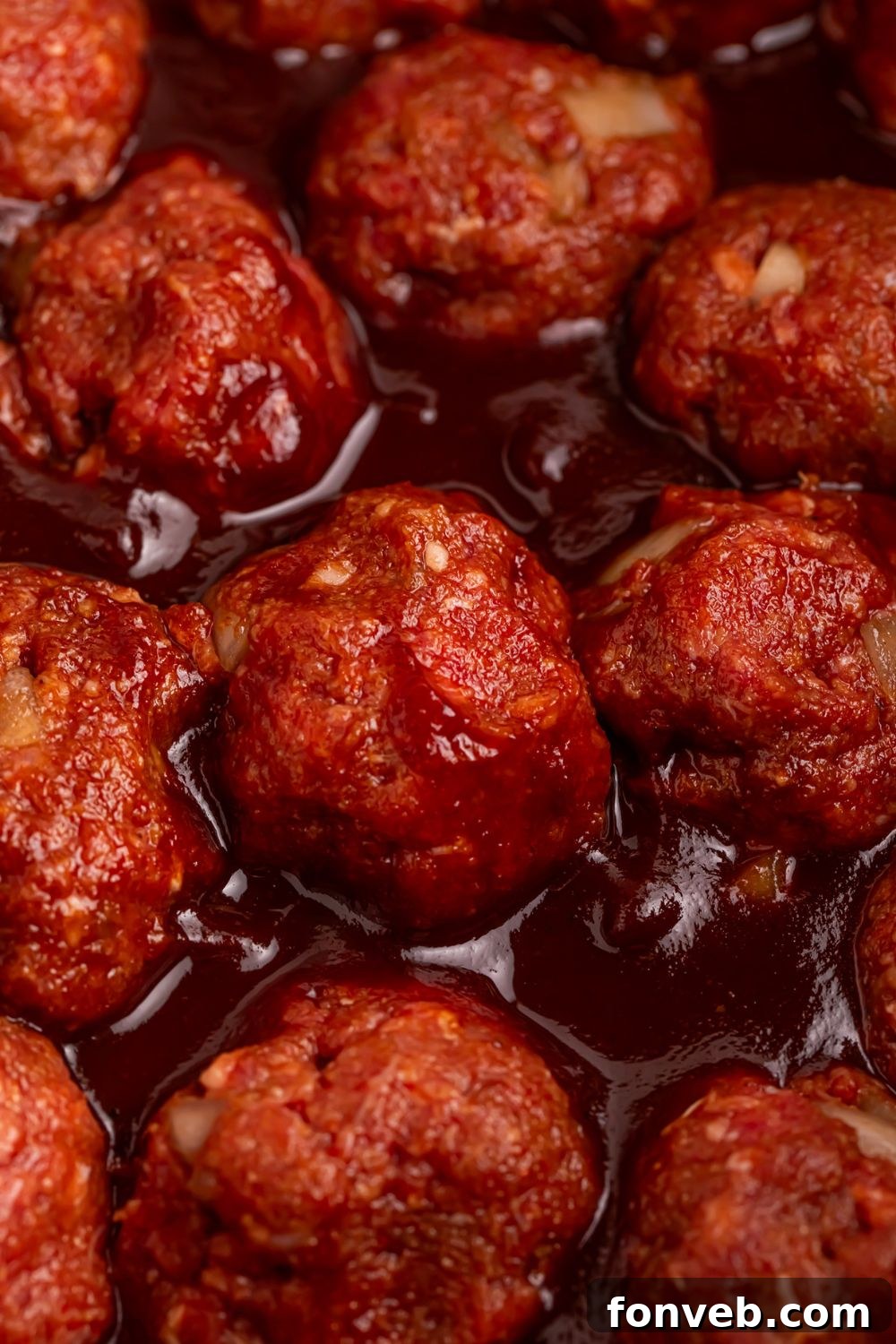 close up of meatballs in a bbq sauce being cooked in a CrockPot