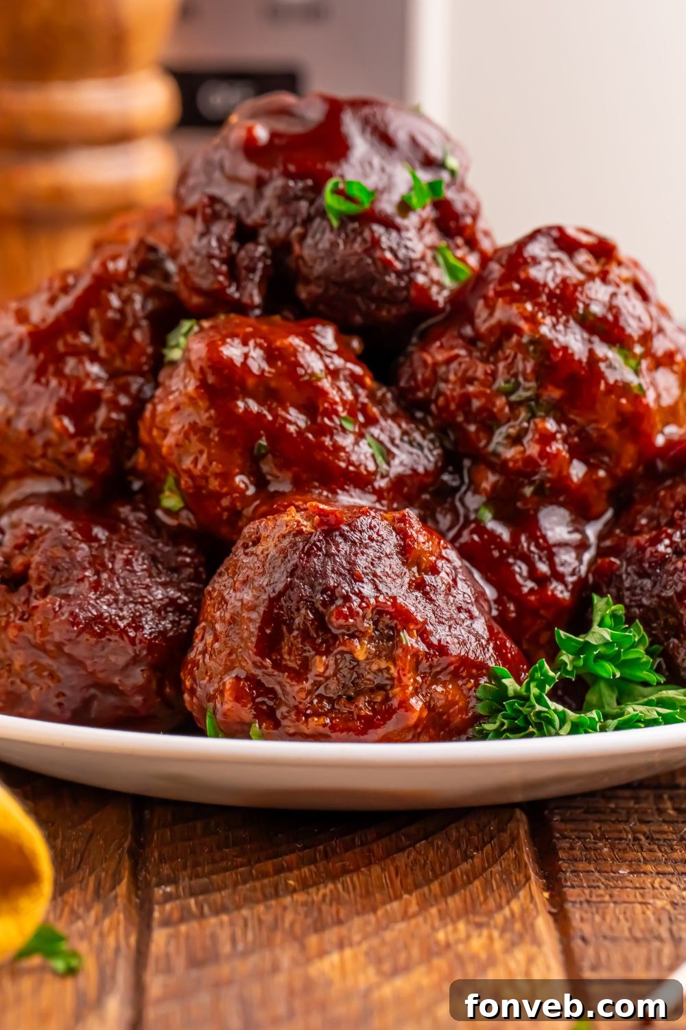 Crockpot Homemade BBQ Meatballs placed on a plate with salt and pepper shaker to side of table 