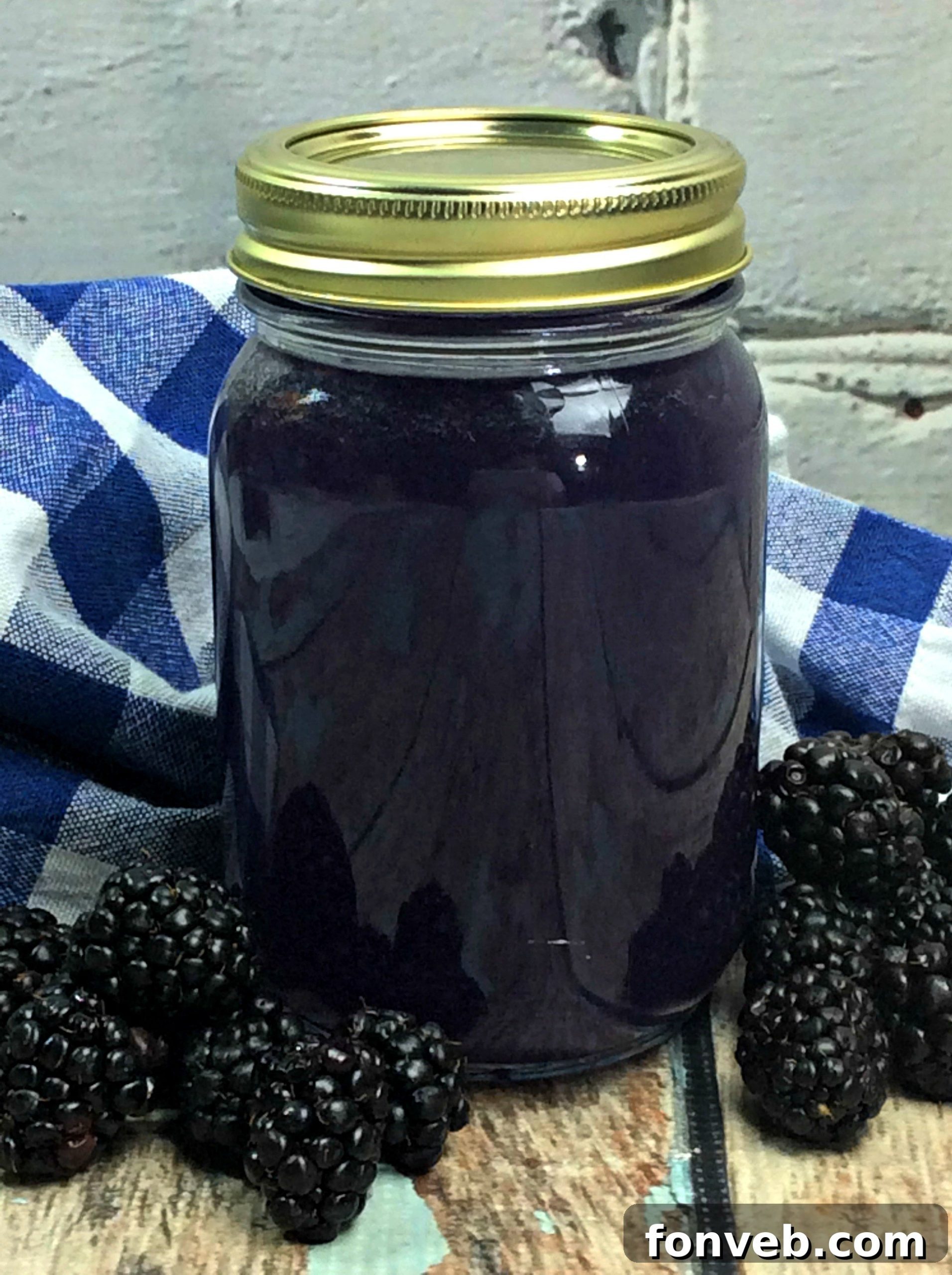 Wild Berry Firewater 2 Homemade Blackberry Moonshine in Mason Jars, close-up with fresh blackberries.