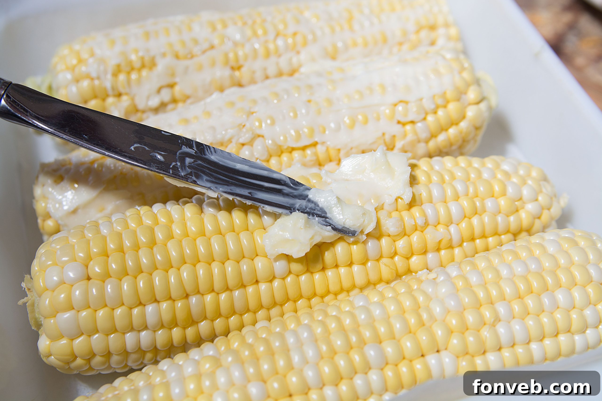 A vibrant pile of fresh corn on the cob, ready for cooking, highlighting its natural beauty and abundance.