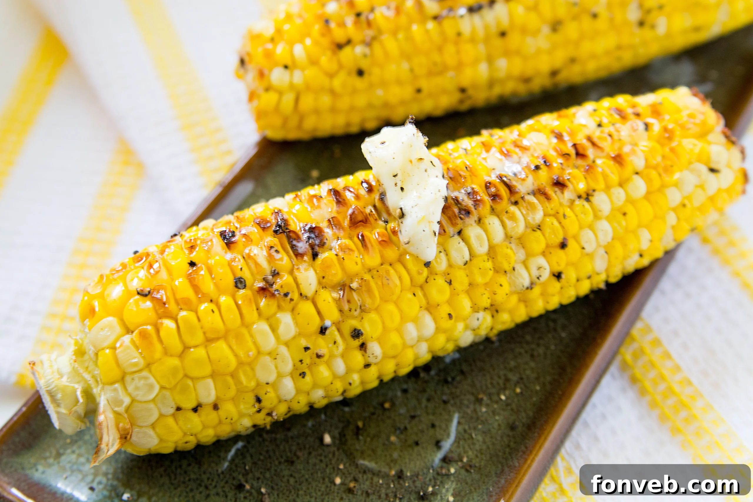Deliciously roasted corn on the cob, generously covered in melted butter and spices, served hot.