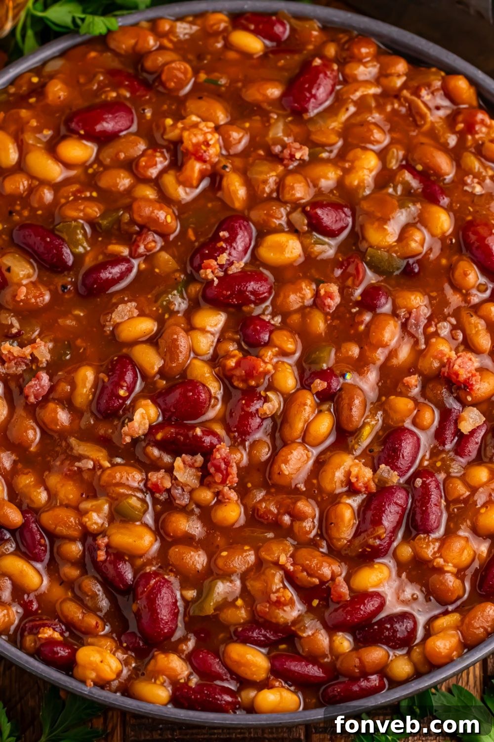 Crockpot bourbon baked beans in a black bowl sitting on table 