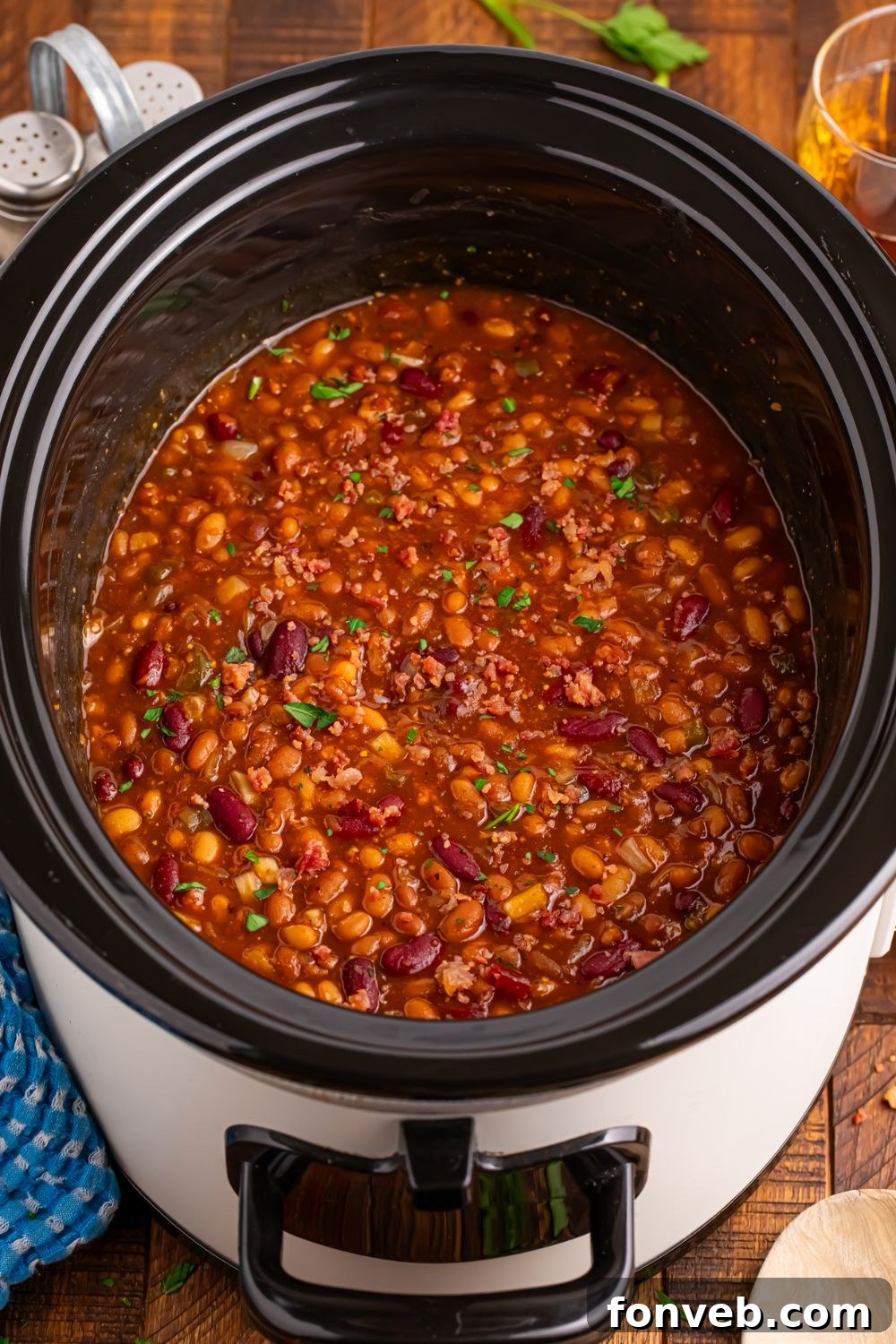 crockpot sitting on table with bourbon baked beans inside 