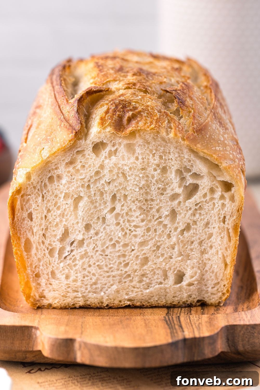 Effortless Homemade Sourdough Perfectly Crusty Always 21 Homemade Sourdough Bread on a cutting board with some cut off to see the chewy center of bread