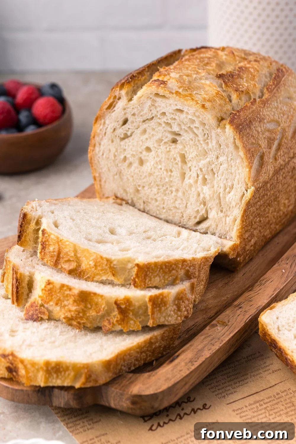 Effortless Homemade Sourdough Perfectly Crusty Always 22 Homemade Sourdough Bread on a tray on table with some of the bread sliced to show the texture