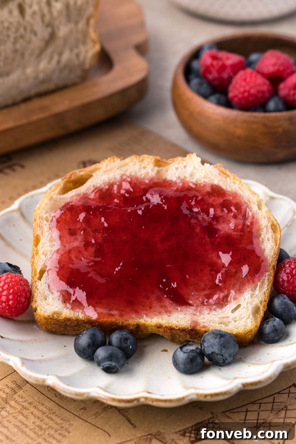Effortless Homemade Sourdough Perfectly Crusty Always 24 Homemade Sourdough Bread sliced on plate with jam, and berries around it