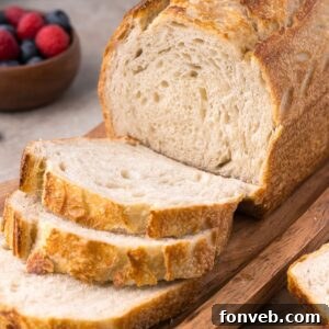 Effortless Homemade Sourdough Perfectly Crusty Always 31 Homemade Sourdough Bread on cutting board with a few slices cut out of the loaf of bread