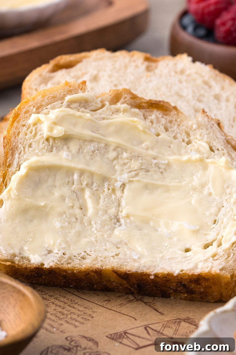 Effortless Homemade Sourdough Perfectly Crusty Always 6 sliced Homemade Sourdough Bread with butter on top of the bread sitting on table