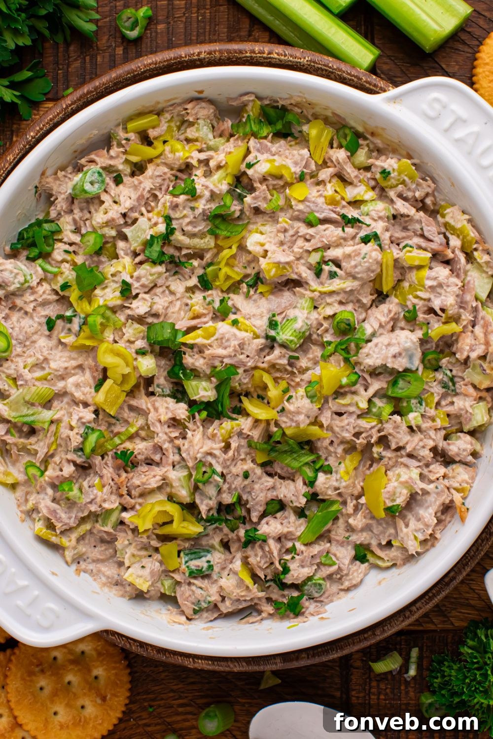 overhead look of a large bowl of Pepperoncini Ranch Tuna Salad on table with some celery to side and fresh parsley bundle 