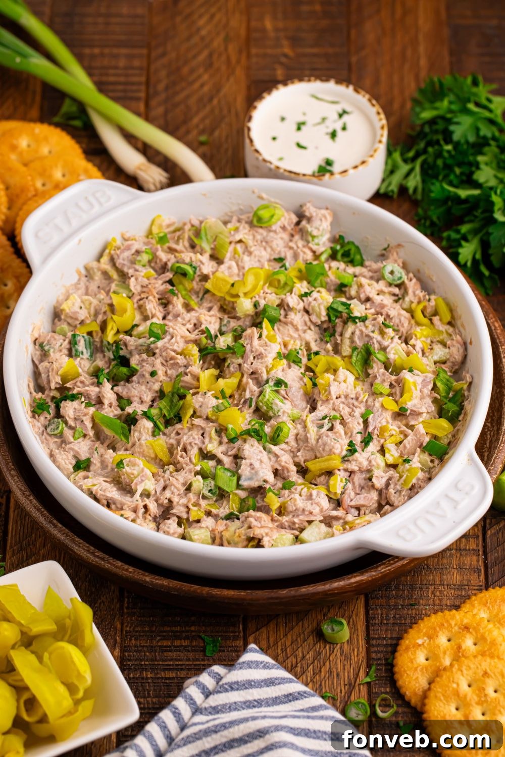 table set up with green onions, ranch dressing in a bowl, crackers, and a bowl of Pepperoncini Ranch Tuna Salad