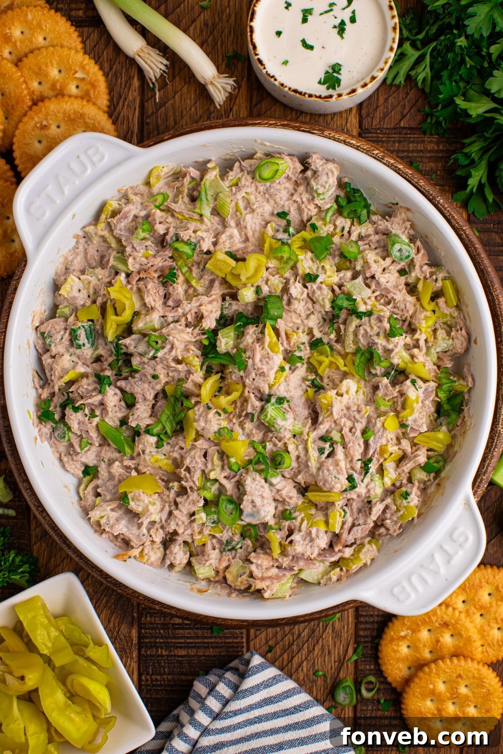 overhead look of white bowl on table with Pepperoncini Ranch Tuna Salad and crackers and peppers beside the bowl 