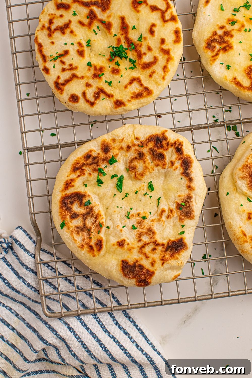 Freshly cooked 3-Ingredient Flatbreads cooling on a wire rack with a cloth underneath