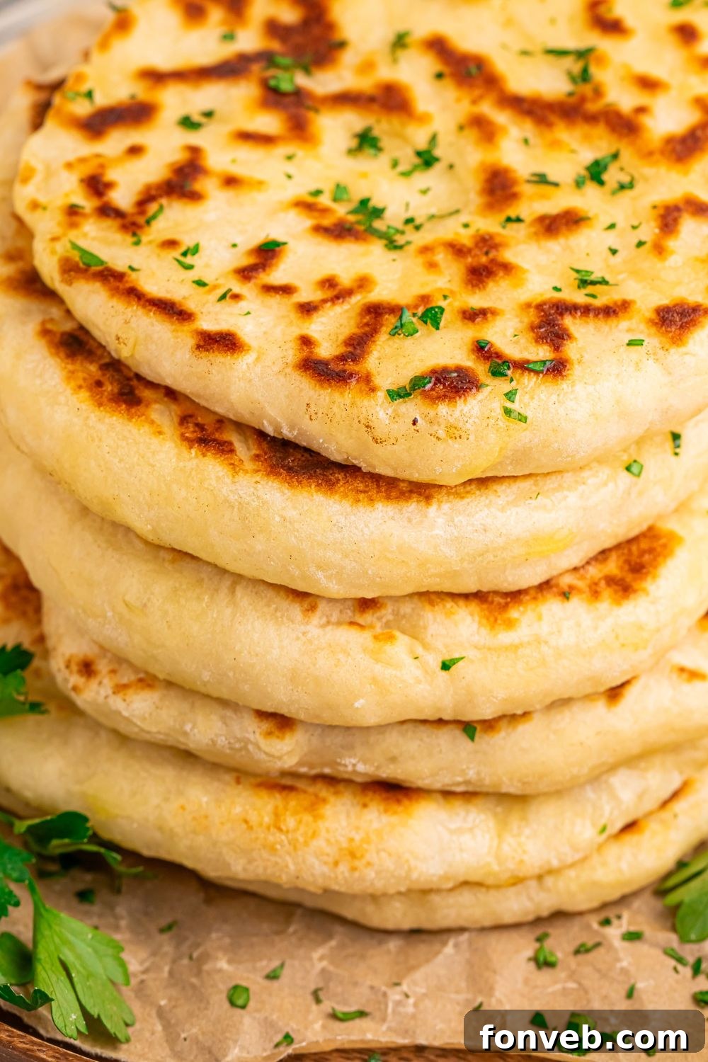 A stack of 3-Ingredient Flatbreads on a tray, with chopped parsley sprinkled on the table