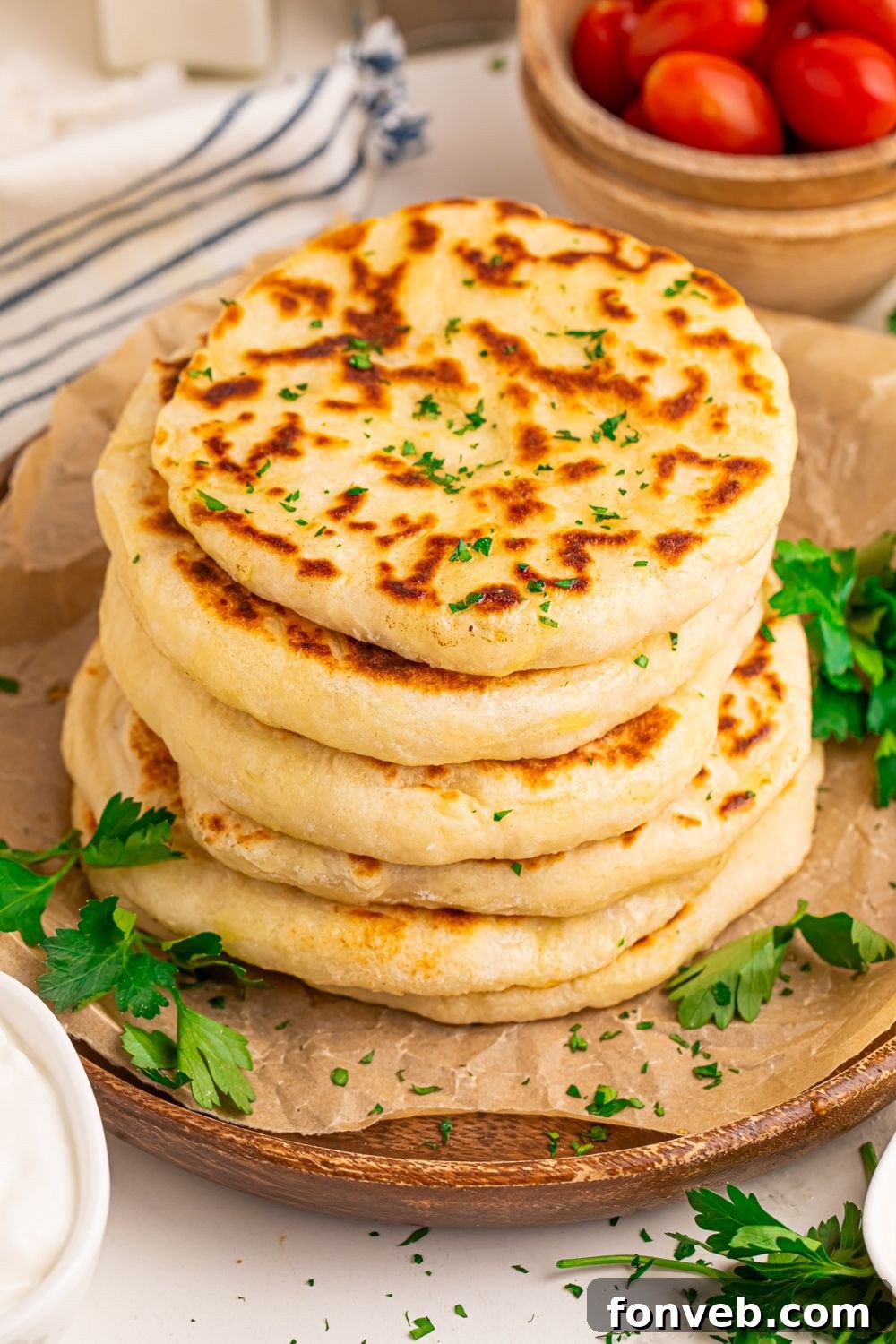 A stack of 3-Ingredient Flatbreads on a tray with bowls of cherry tomatoes on the side