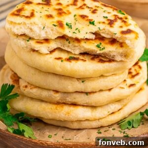 3 Ingredient Flatbread stacked on table with parsley sprinkled on top and some around platter