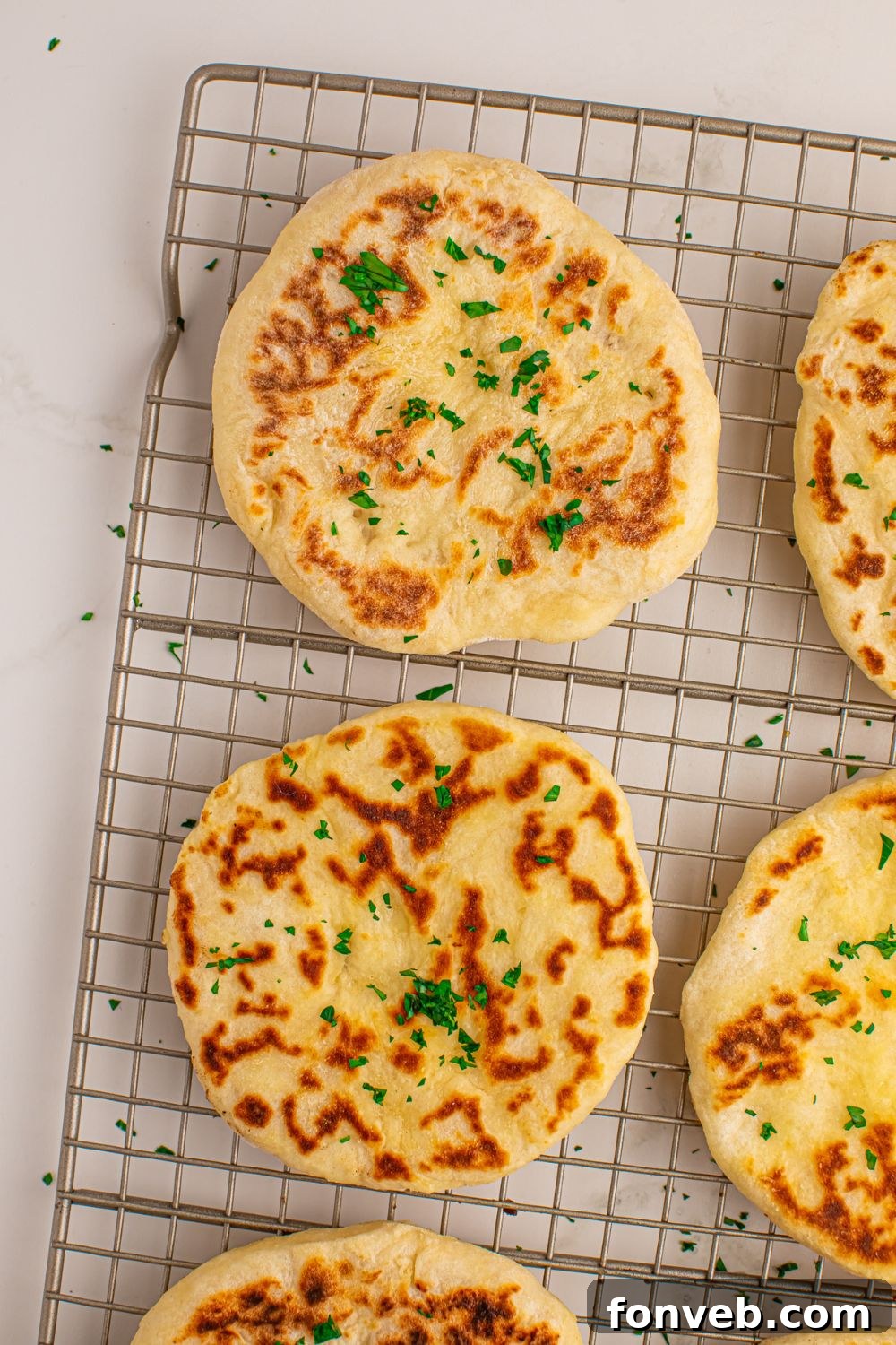 Freshly cooked 3-Ingredient Flatbreads cooling on a wire rack on a wooden table