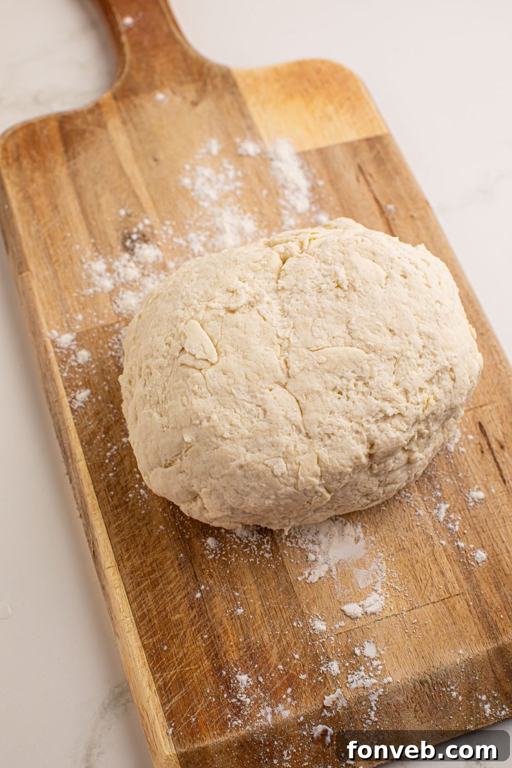 Smooth 3-Ingredient Flatbread dough resting on a wooden cutting board