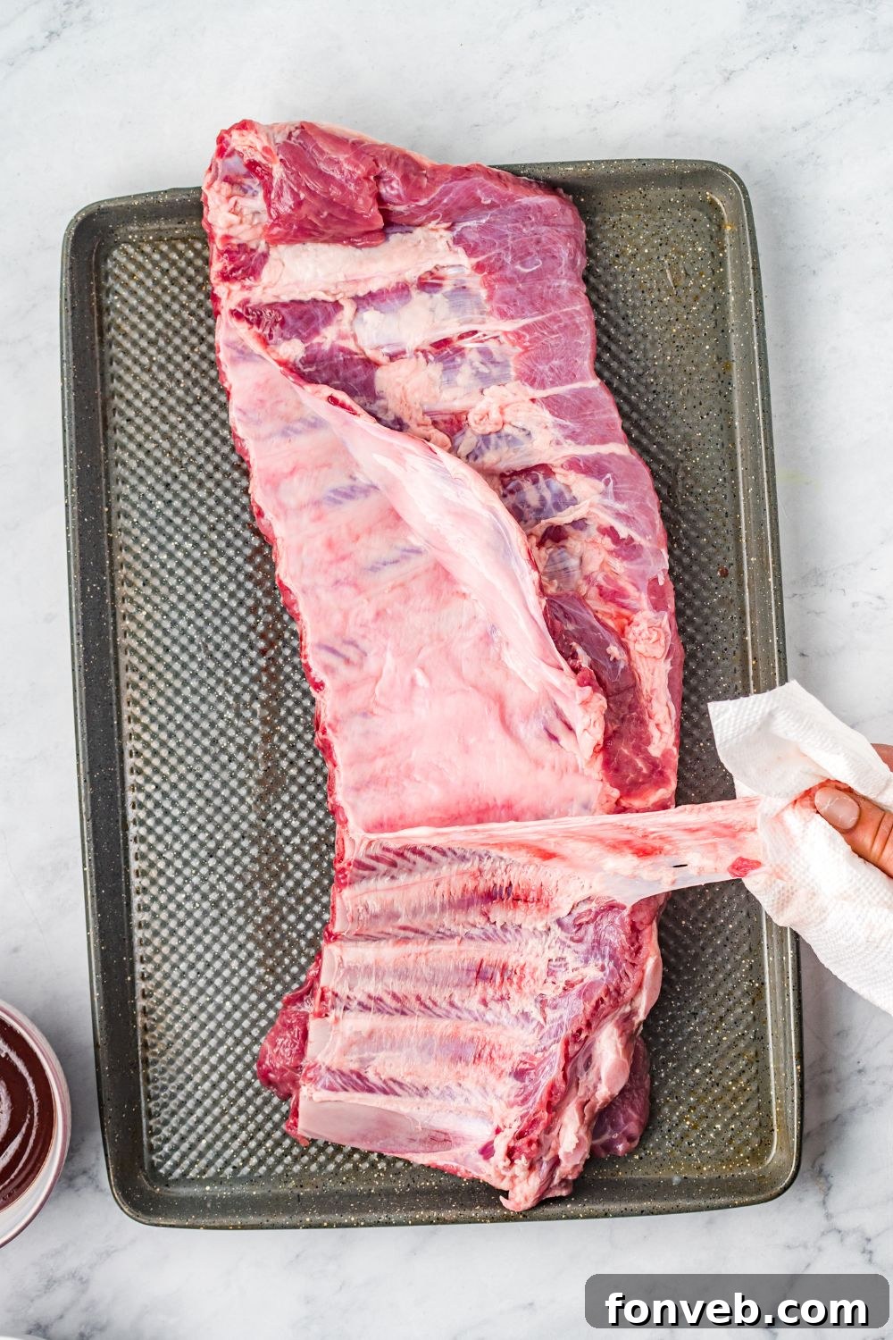 peeling silverskin off a slab of ribs