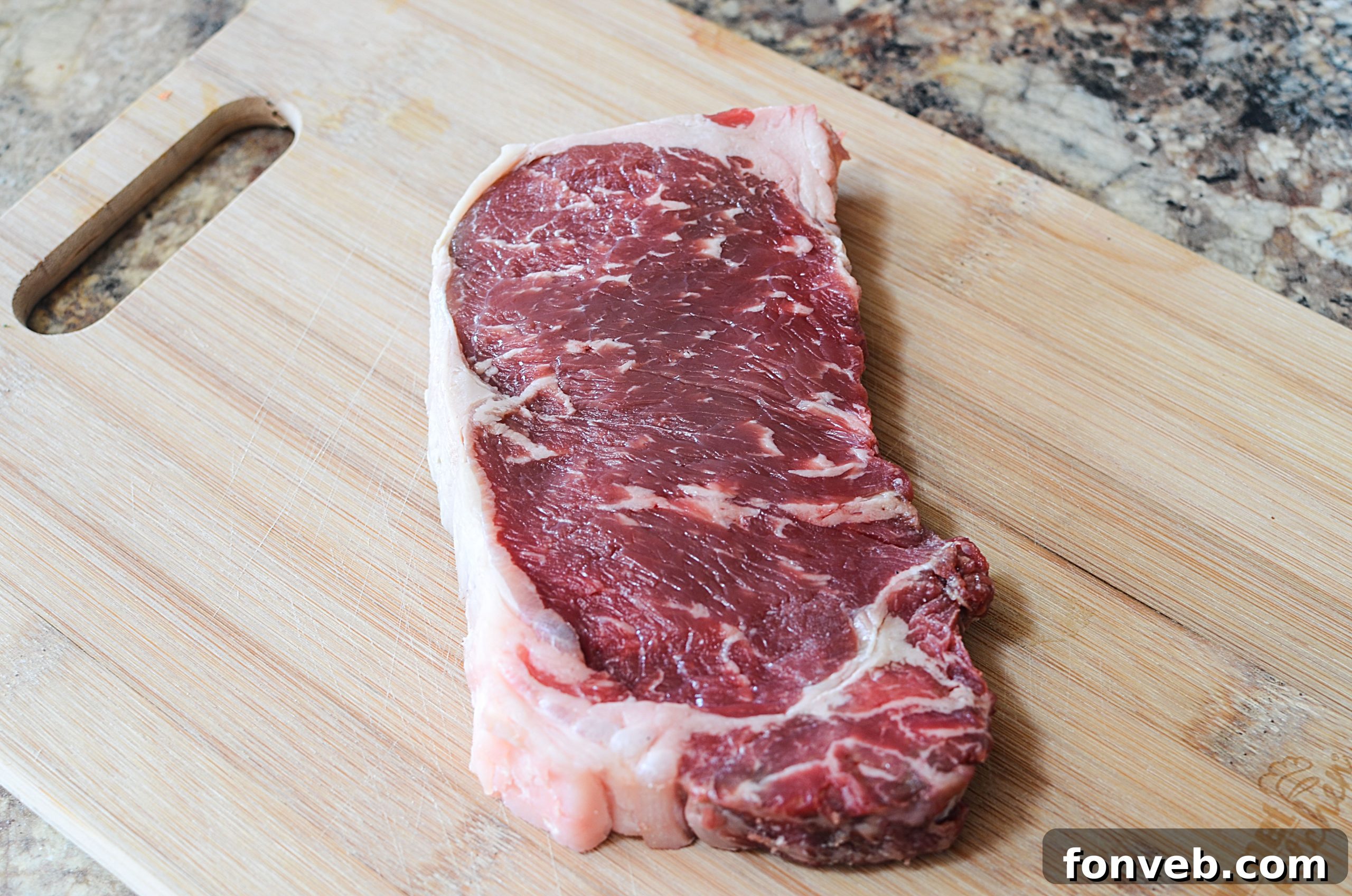 Close-up of a grilled steak, perfectly seared with a beautiful crust and visible juices, ready to be sliced and served.