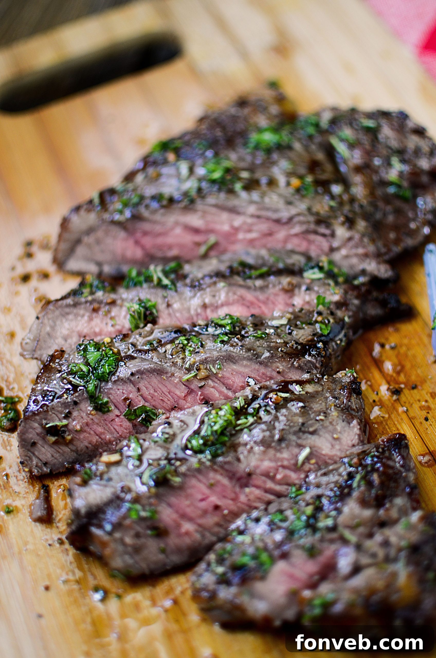 A close-up of a grilled steak, expertly sliced, revealing the succulent, pink interior and rich juices. This is how perfect steak looks!