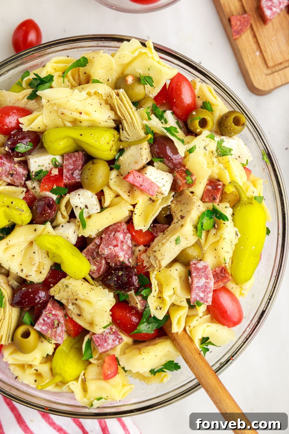 Antipasto Tortellini Pasta Salad on table in a bowl with overhead look of pasta and meat in bowl 