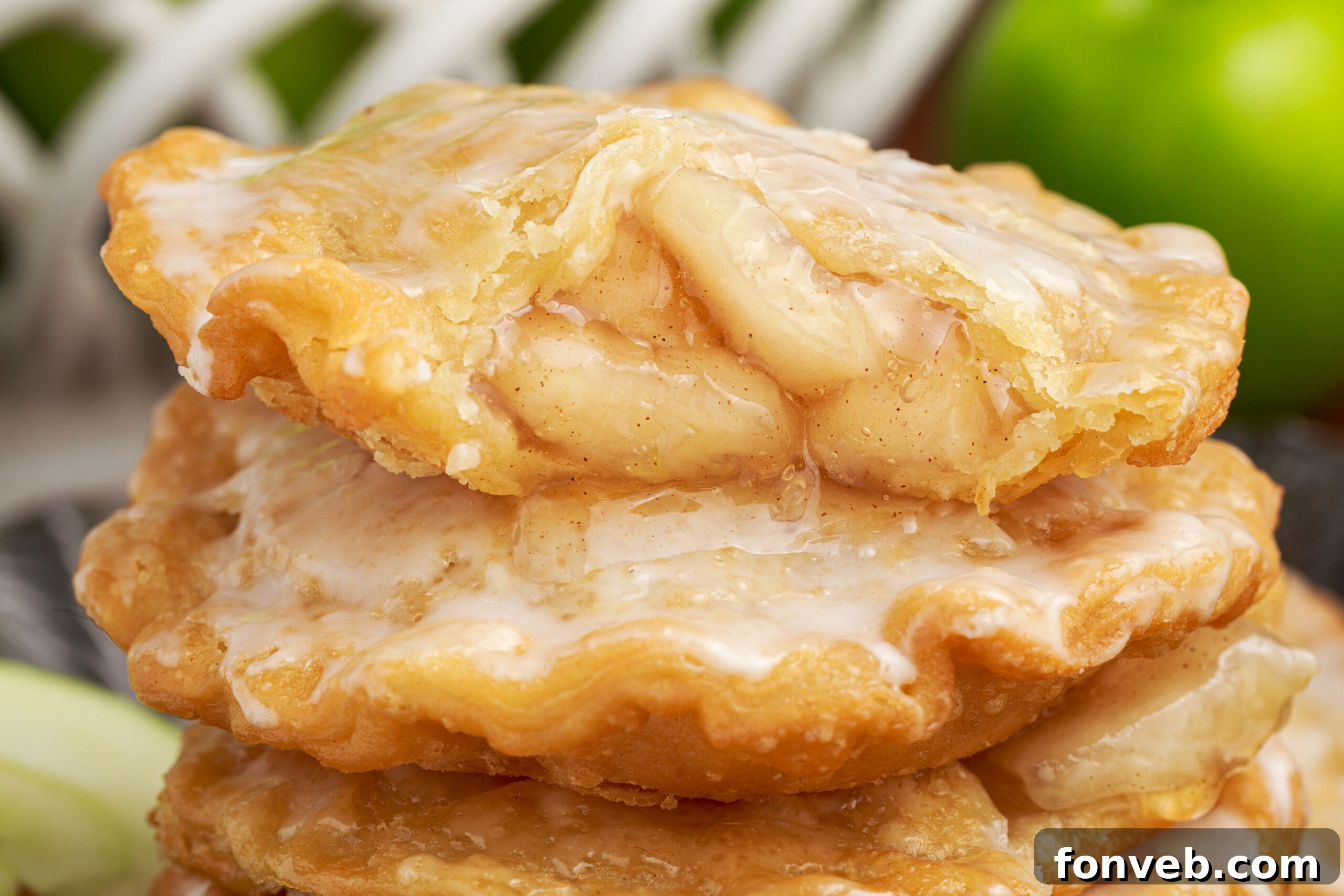 Golden Glazed Apple Hand Pies 24 Deep Fried Apple Hand Pies stacked on top of each other with one that has a bite taken out of it
