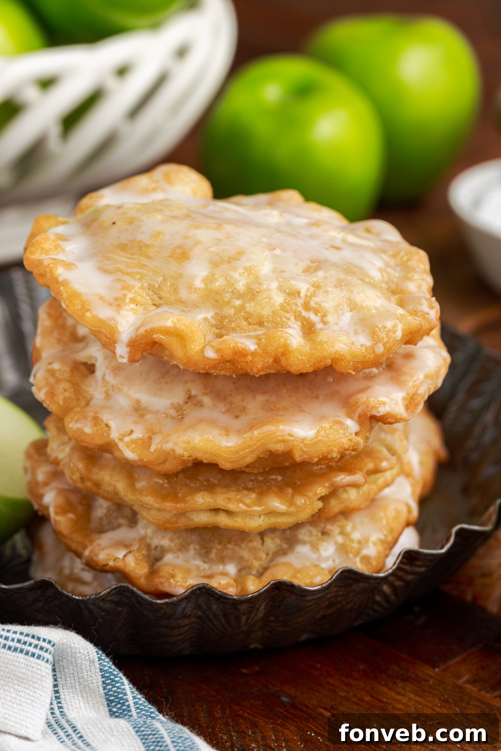 Golden Glazed Apple Hand Pies 26 stack of Deep Fried Apple Hand Pies on top of each other drizzled with glaze