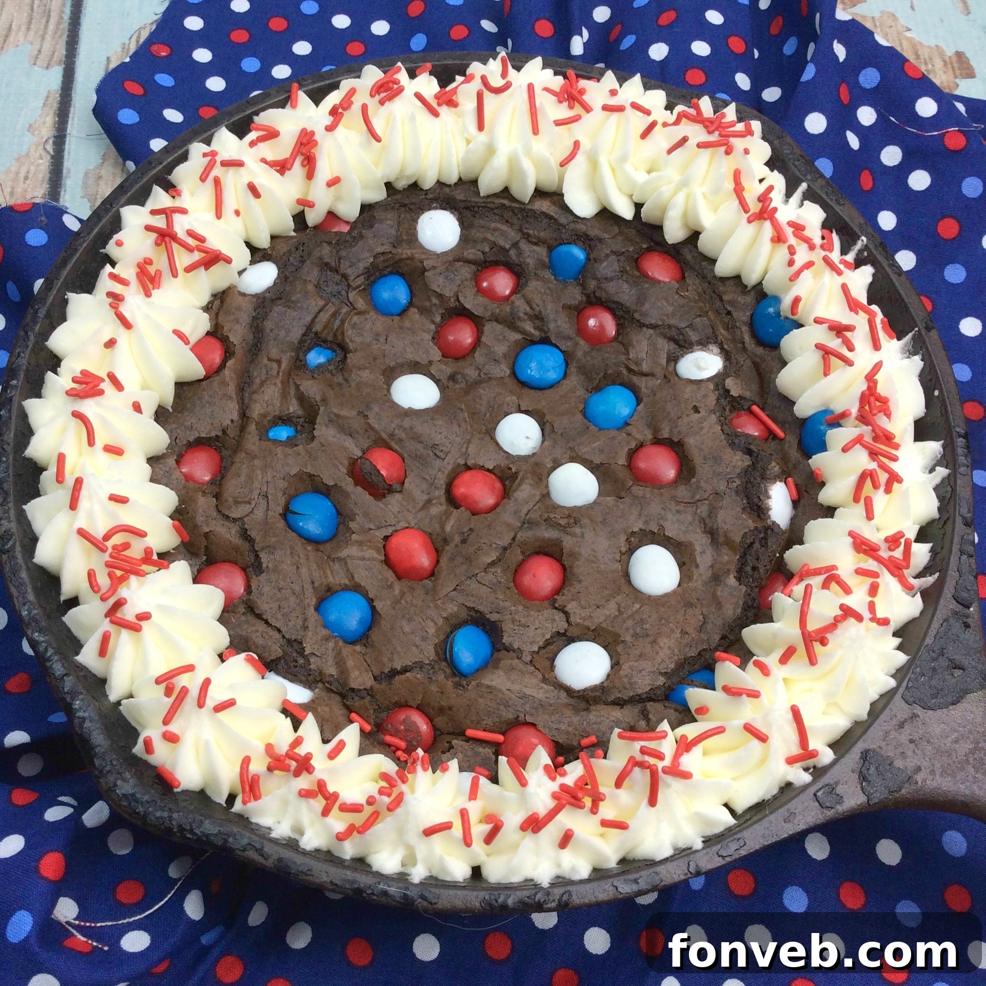 Gooey Skillet Fudge Brownie Perfection 4 A warm Cast Iron Fudge Brownie Skillet topped generously with scoops of melting vanilla ice cream and colorful M&Ms, ready to be enjoyed.