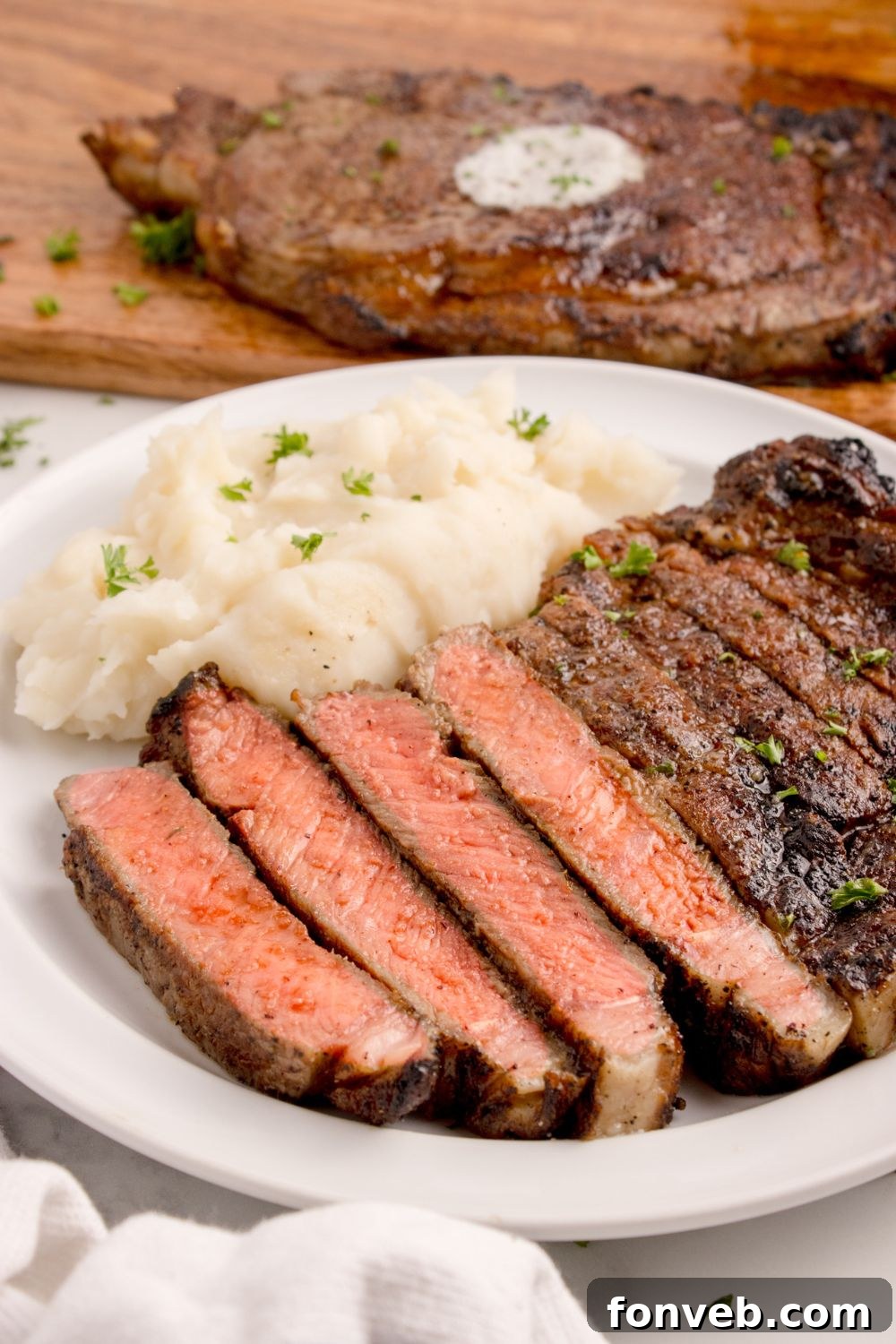 plate with mashed potatoes and sliced Grilled Ribeye Steak on plate 