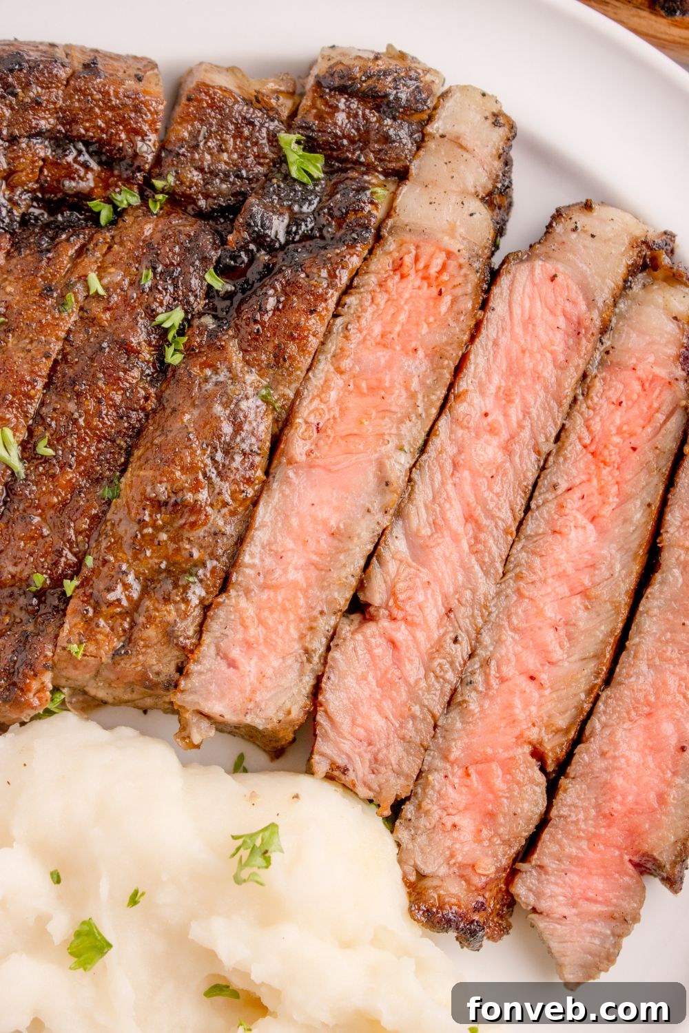 Grilled Ribeye Steak cut into thicker strips showing the medium rare doneness of the steak 
