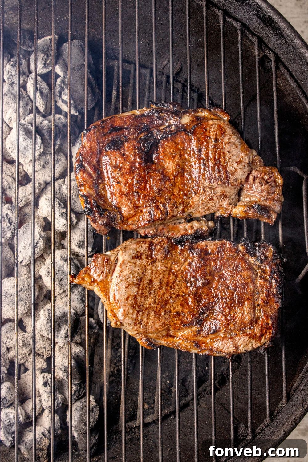 charcoal grill with Grilled Ribeye Steaks on top of grill 