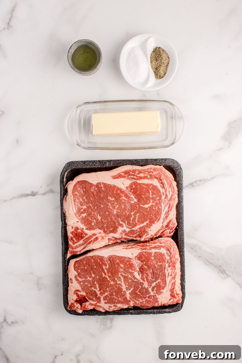 Grilled Ribeye Steaks ingredients on marble counter 