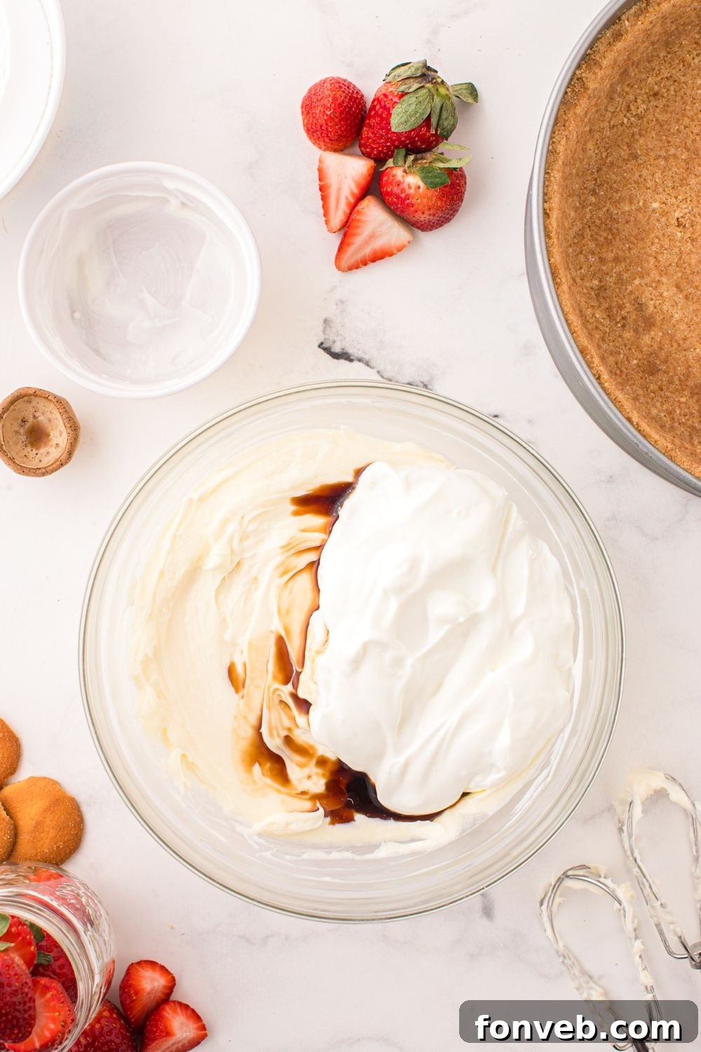 ingredients to make a No Bake Strawberry Cheesecake in a bowl on table 