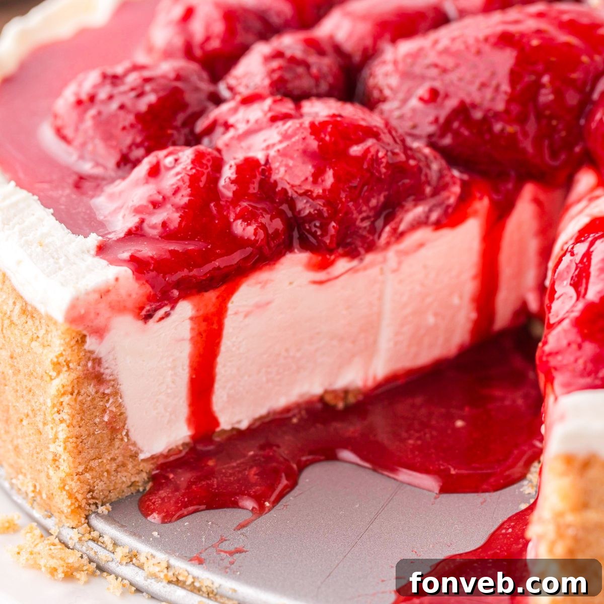 No Bake Strawberry Cheesecake on tray with a slice taken out to see how decadent the cheesecake is 