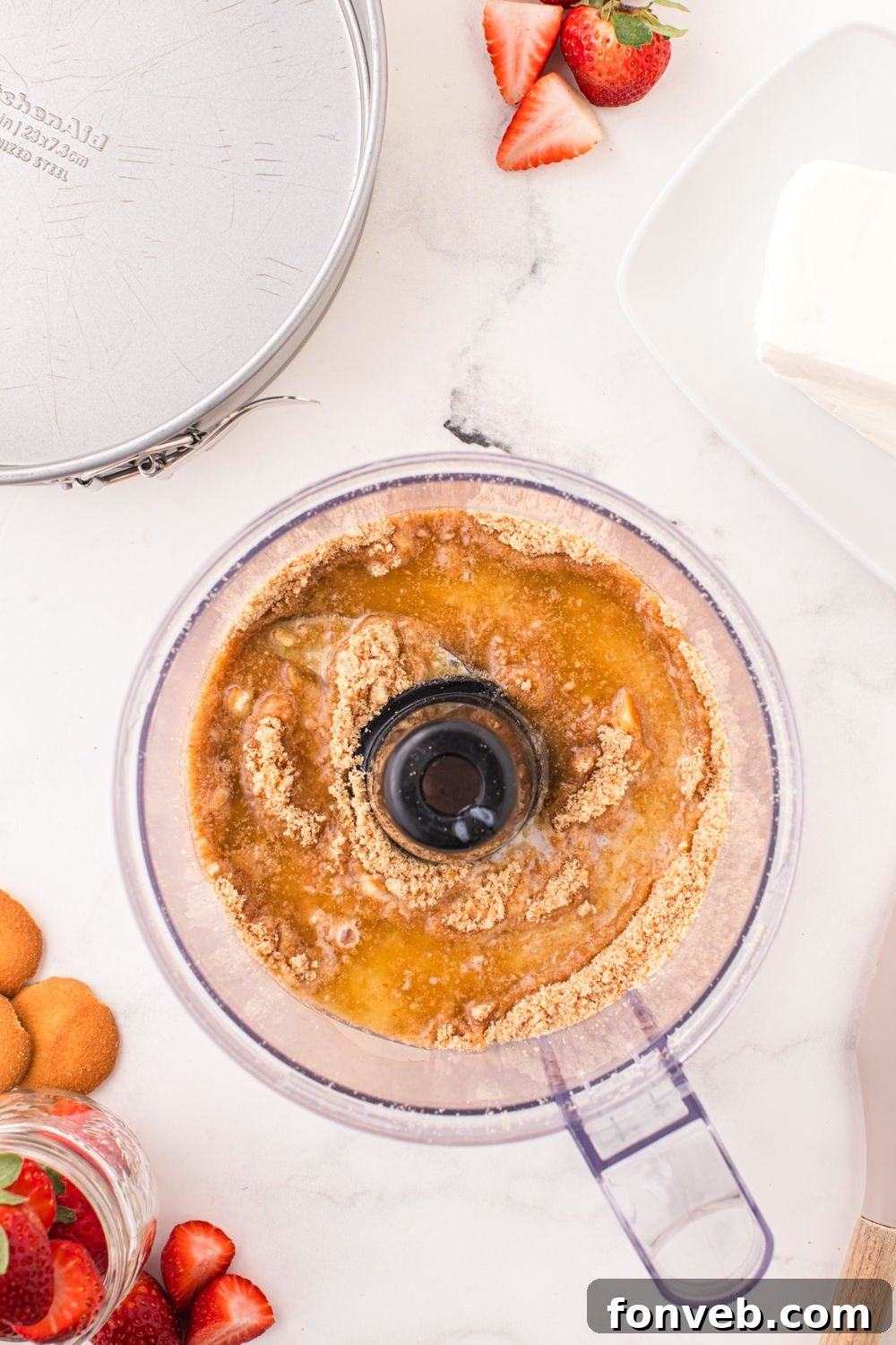 ground up vanilla wafers and butter in a food processor on table