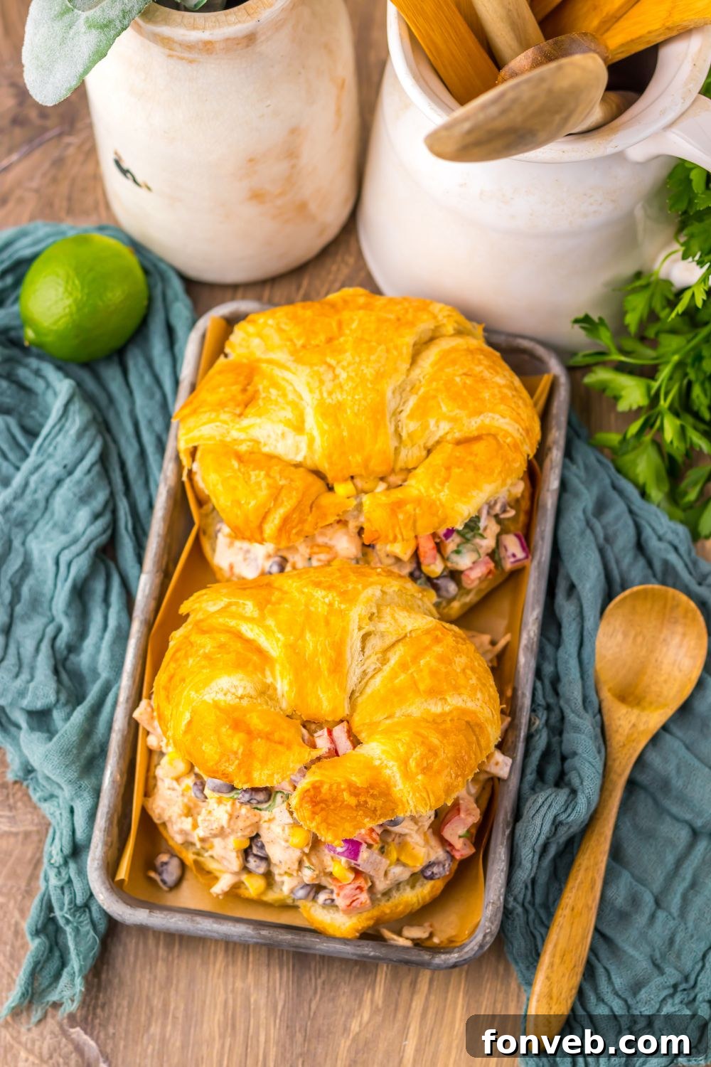 overhead look of table with Creamy Taco Chicken Salad  sandwiches on table with lime and cilantro to side