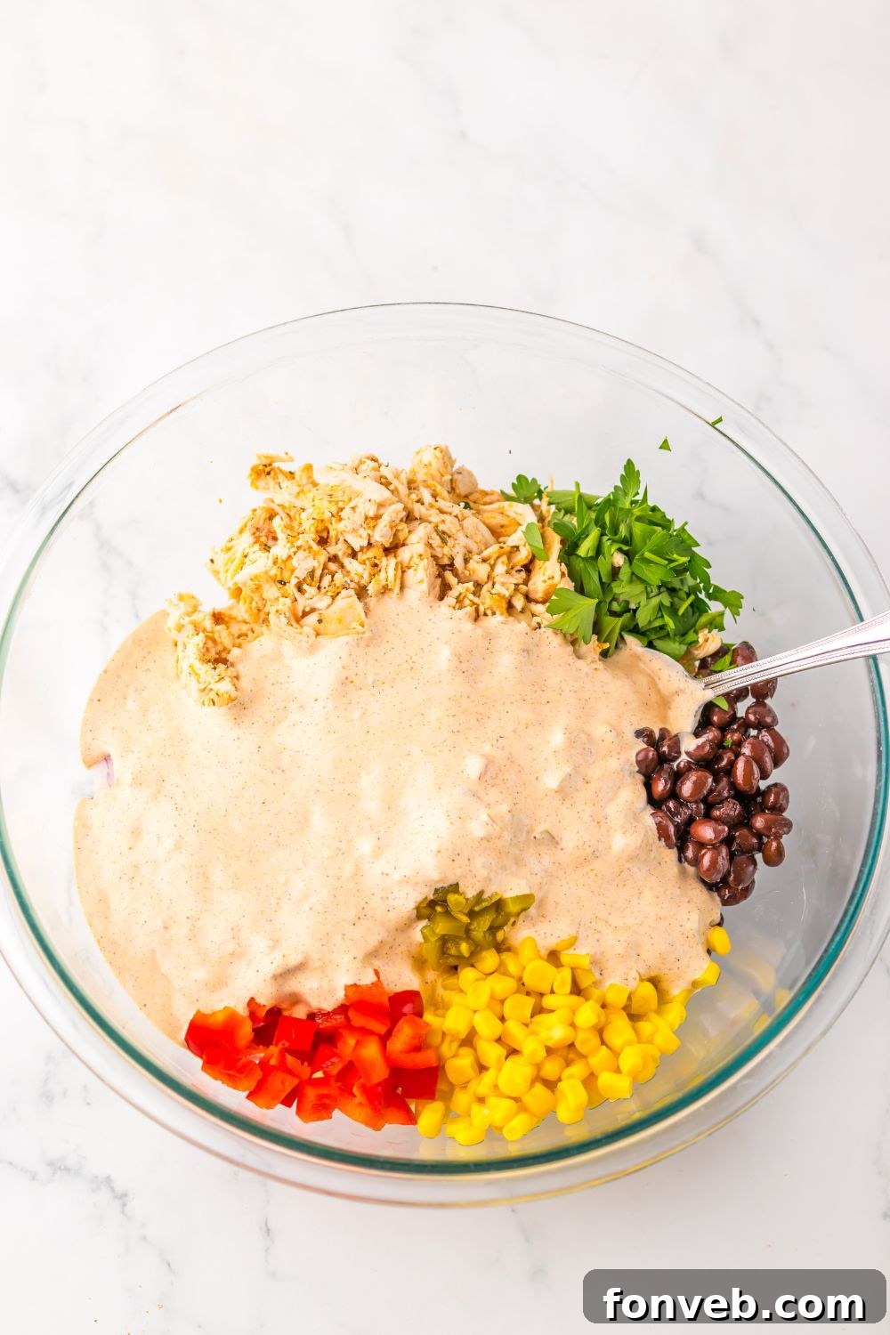 Creamy Taco Chicken Salad  ingredients in a bowl with sauce poured over top