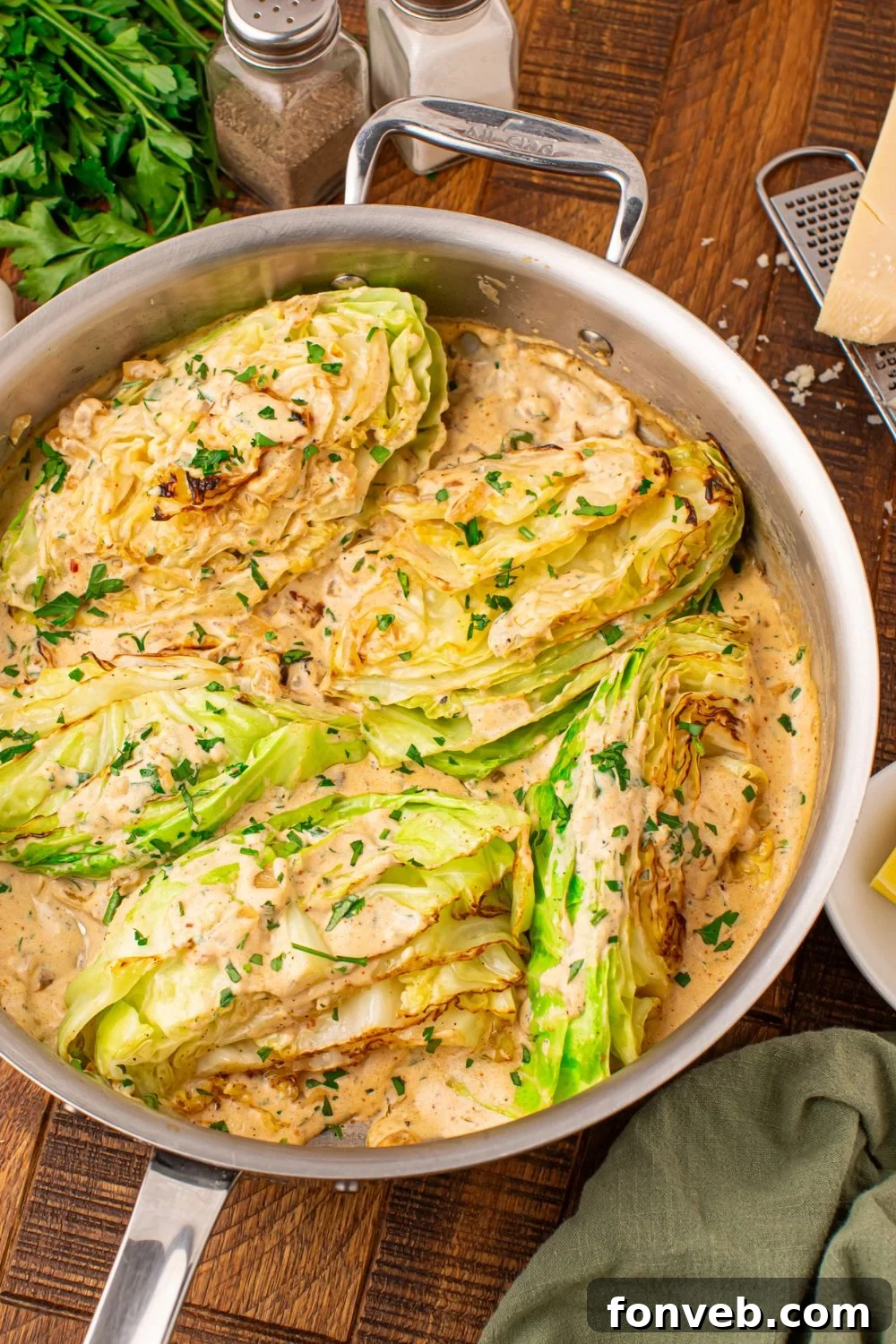 Keto Creamy Garlic Parmesan Cabbage Skillet 19 Garlic cabbage in skillet with a creamy sauce mixed in, and salt and pepper shaker to side of pan