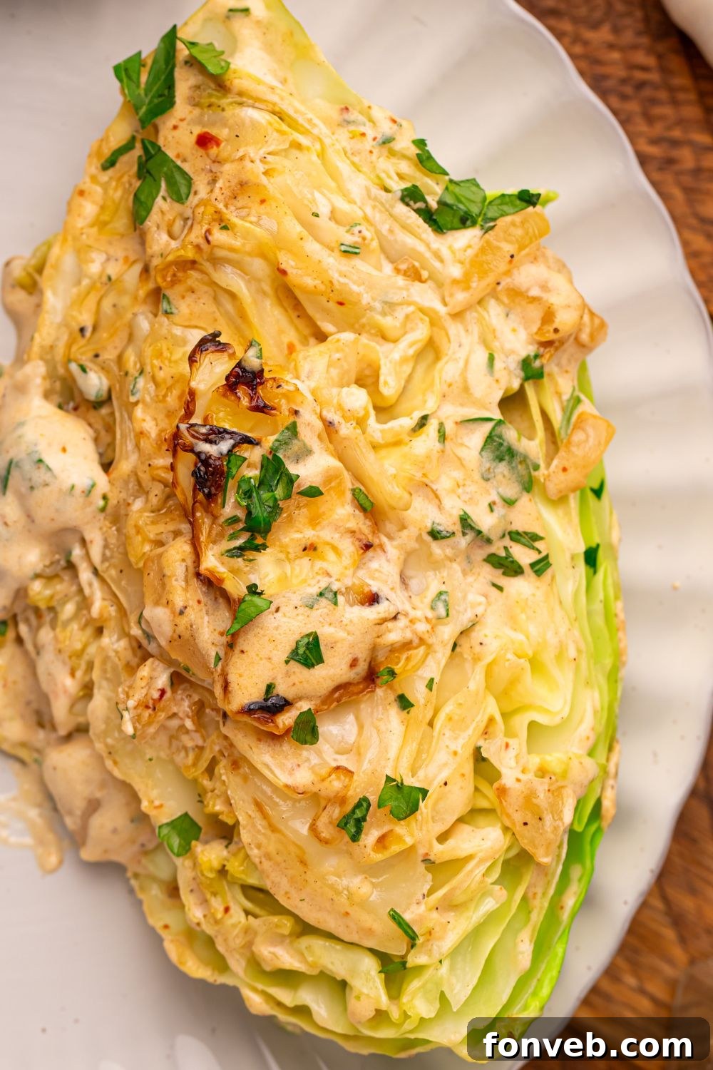 Keto Creamy Garlic Parmesan Cabbage Skillet 20 Creamy Garlic Parmesan Cabbage wedge on a plate topped with parsley
