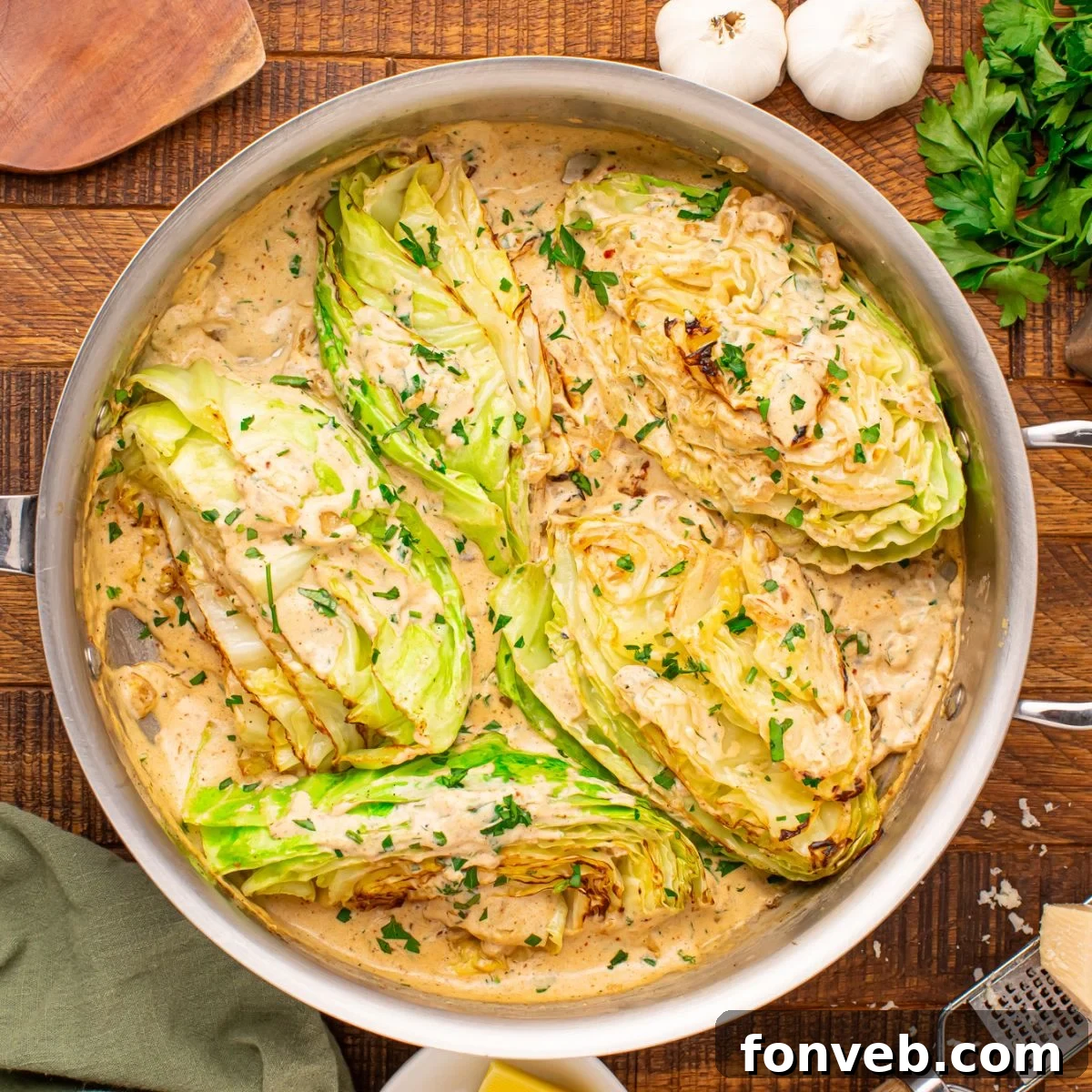 Keto Creamy Garlic Parmesan Cabbage Skillet 3 Creamy Garlic Parmesan Cabbage in a skillet on a rustic table with fresh parsley and garlic